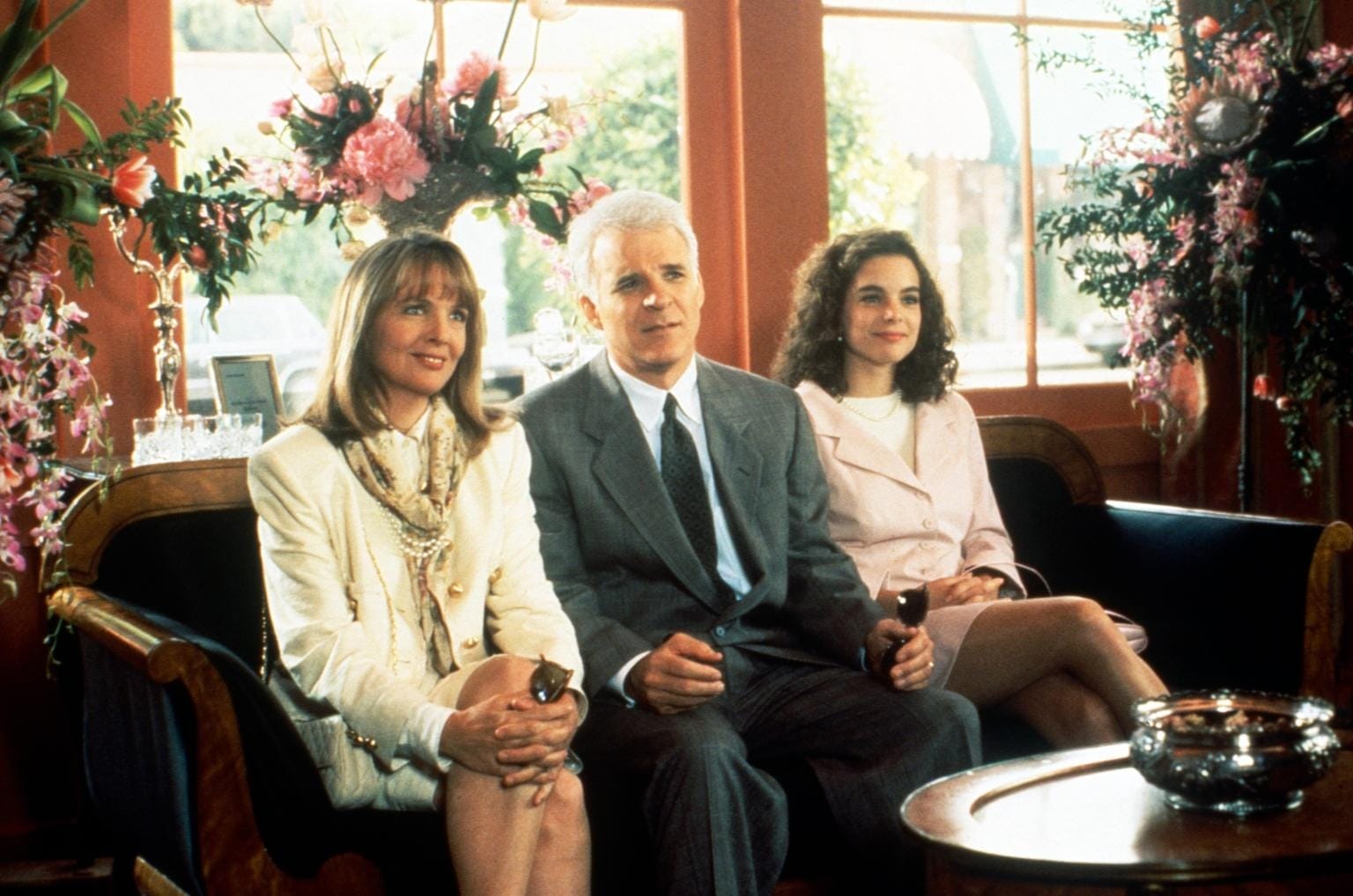 A group of people sit on a couch, including actress Diane Keaton, reminiscent of a cozy lounge at a Disneyland resort hotel.