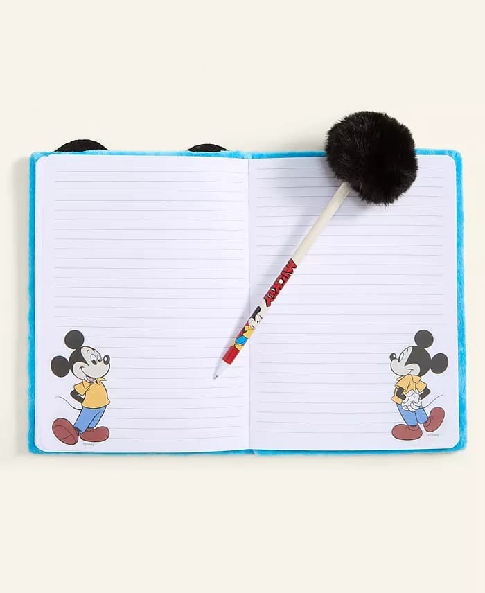 Open notebook with lined pages, Mickey Mouse art similar to park merchandise, and a fluffy pen from Macy's 2025 Holiday Collection.