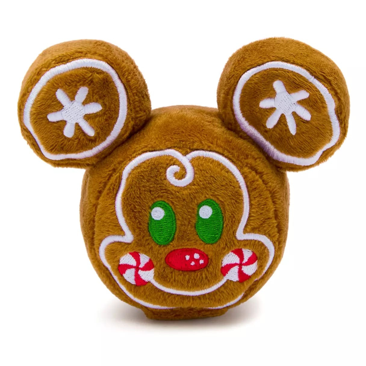 Plush toy shaped like a gingerbread cookie, with green eyes and peppermint cheeks, similar to holiday treats at Disney parks.