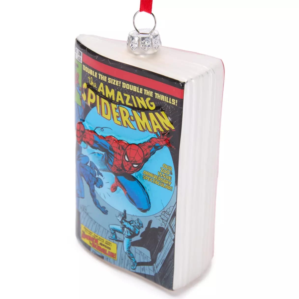 A Christmas ornament shaped like a comic book featuring "The Amazing Spider-Man" cover with Spider-Man swinging.