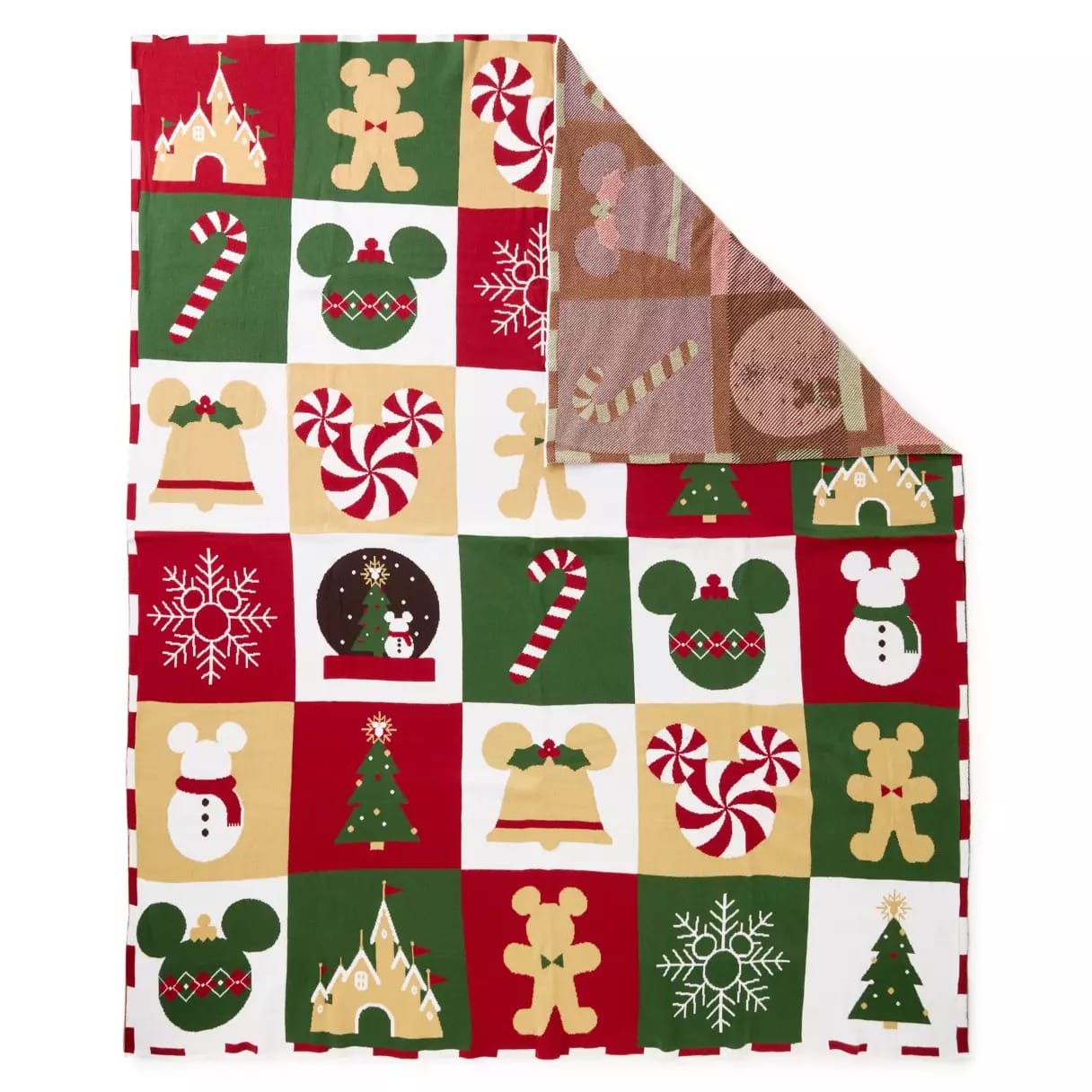 A holiday-themed blanket with red, green, and gold squares featuring cookies, trees, candy canes, snowflakes, and Mickey shapes.