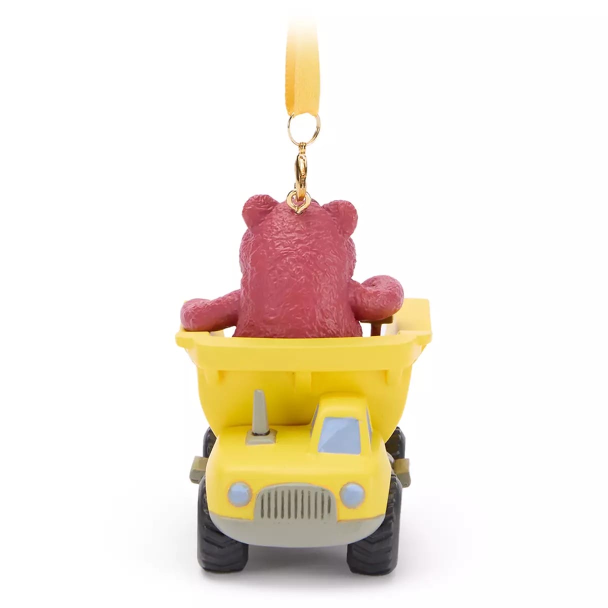 A pink bear figurine sits in the bed of a yellow toy dump truck ornament with a hanging loop.