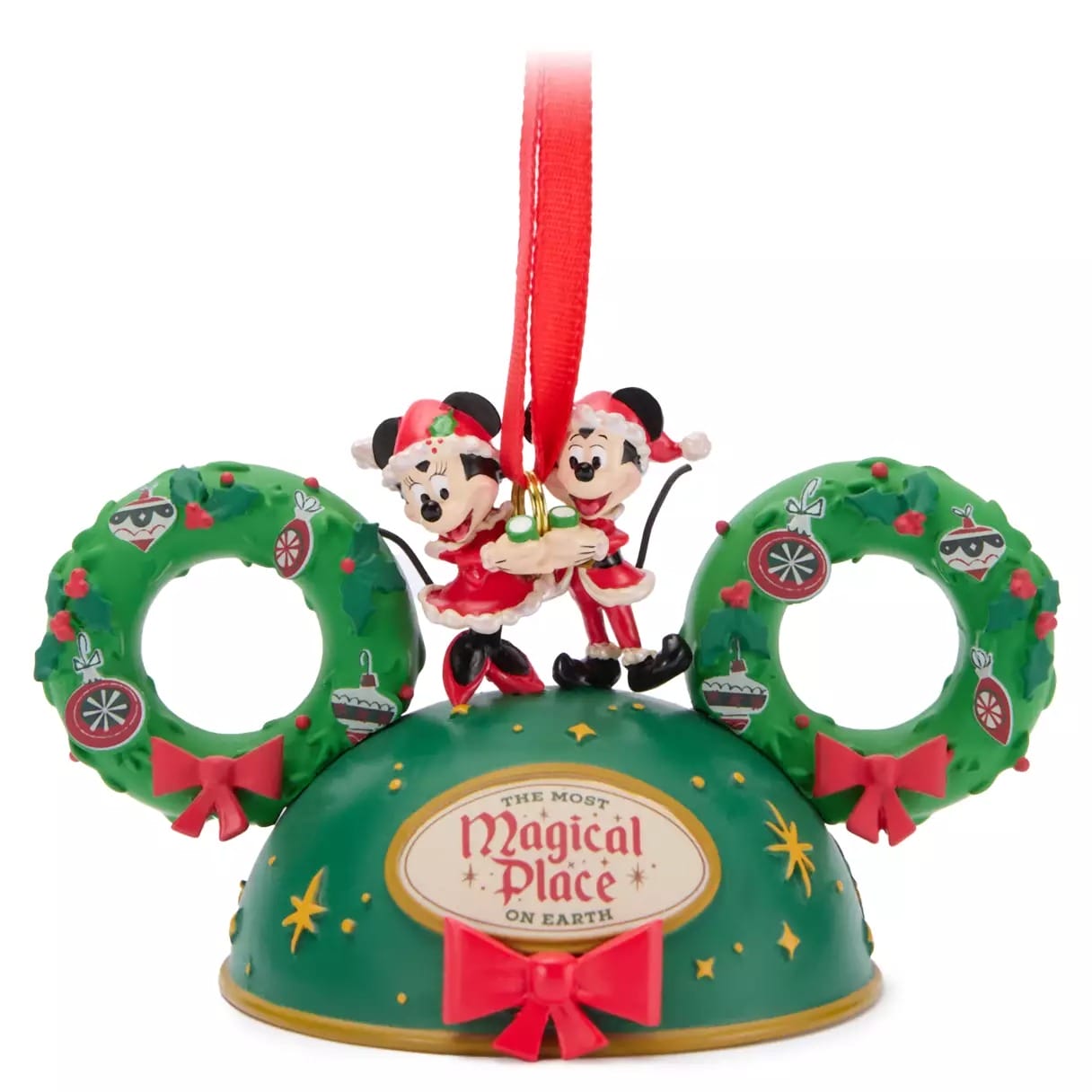Christmas ornament featuring Mickey and Minnie Mouse in holiday outfits on green Mickey ears with wreath decorations.