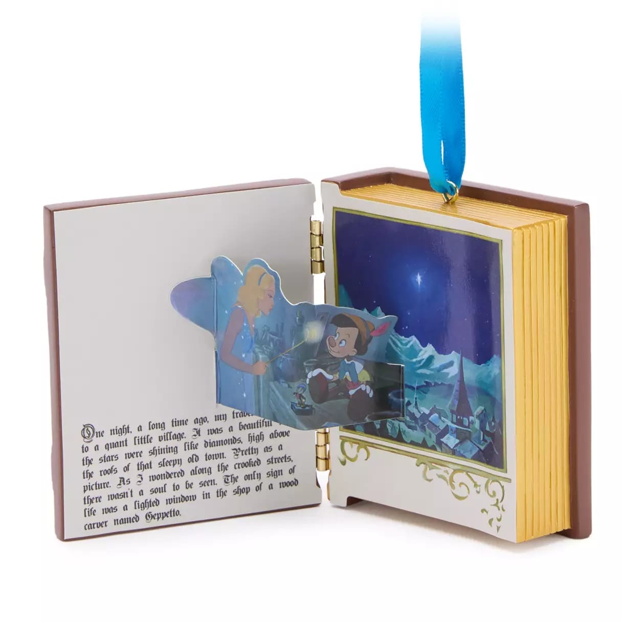 An open storybook ornament from Disney Store, featuring Pinocchio and the Blue Fairy, is perfect 2025 Christmas merchandise.