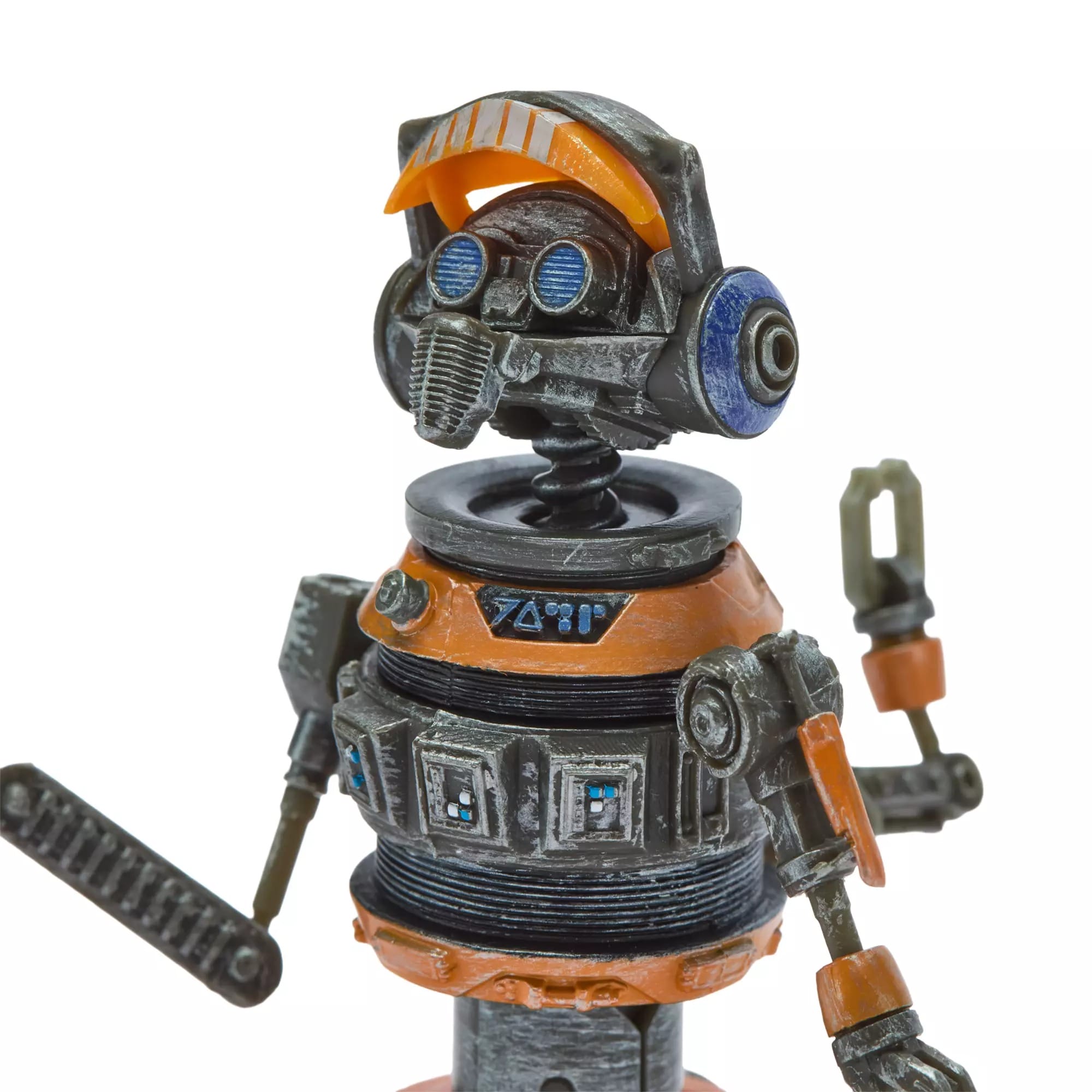 A toy robot with orange and gray accents, blue eyes, and mechanical arms stands against a white backdrop, reminiscent of Tomorrowland.
