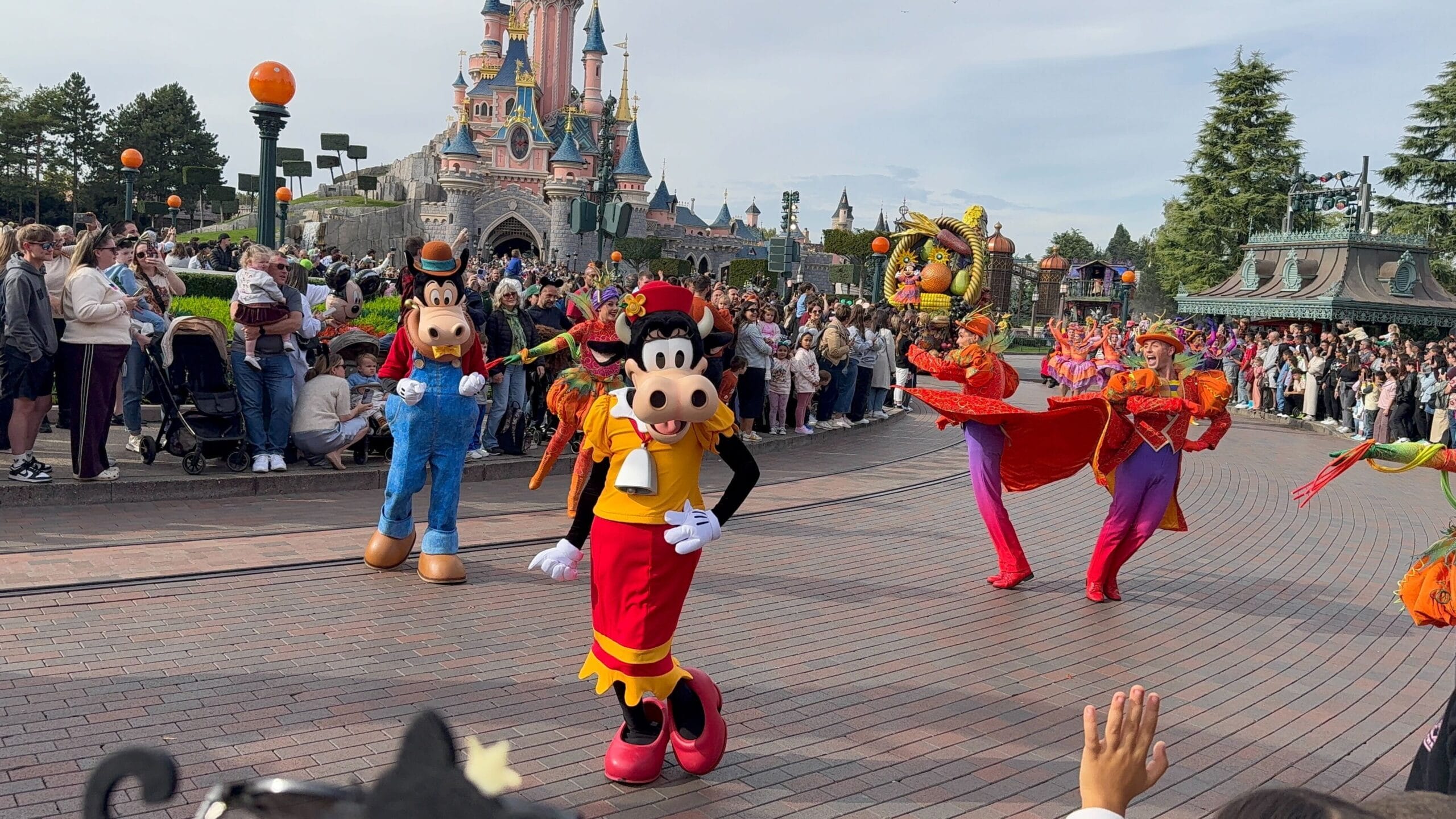 Mickey’s Halloween Celebration Parade 2025 at Disneyland Paris with Clarabelle, Goofy, dancers, and crowds by the castle.