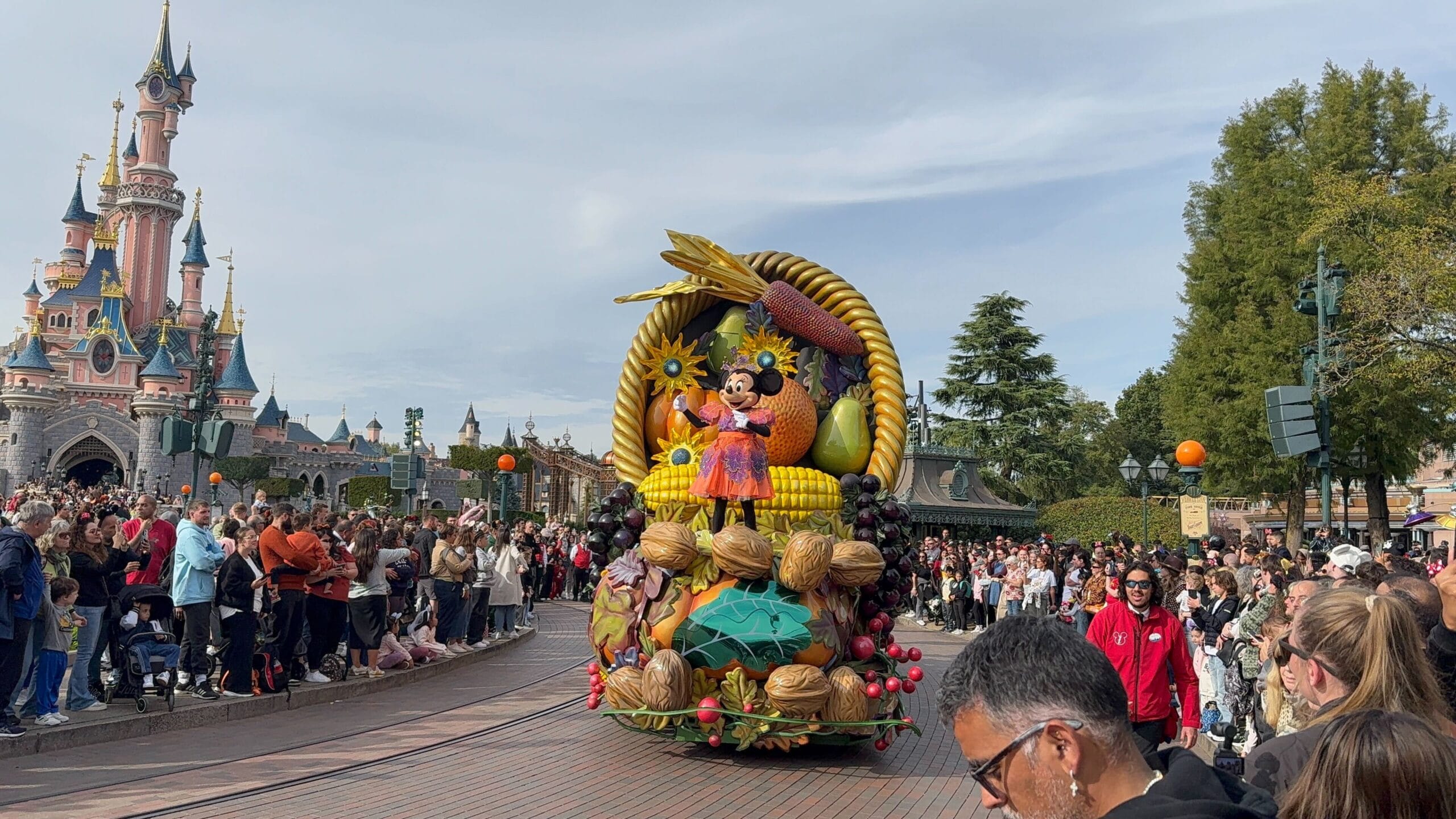 A colorful parade float with Minnie Mouse passes a crowd during Mickey’s Halloween Celebration Parade at Disneyland Paris.