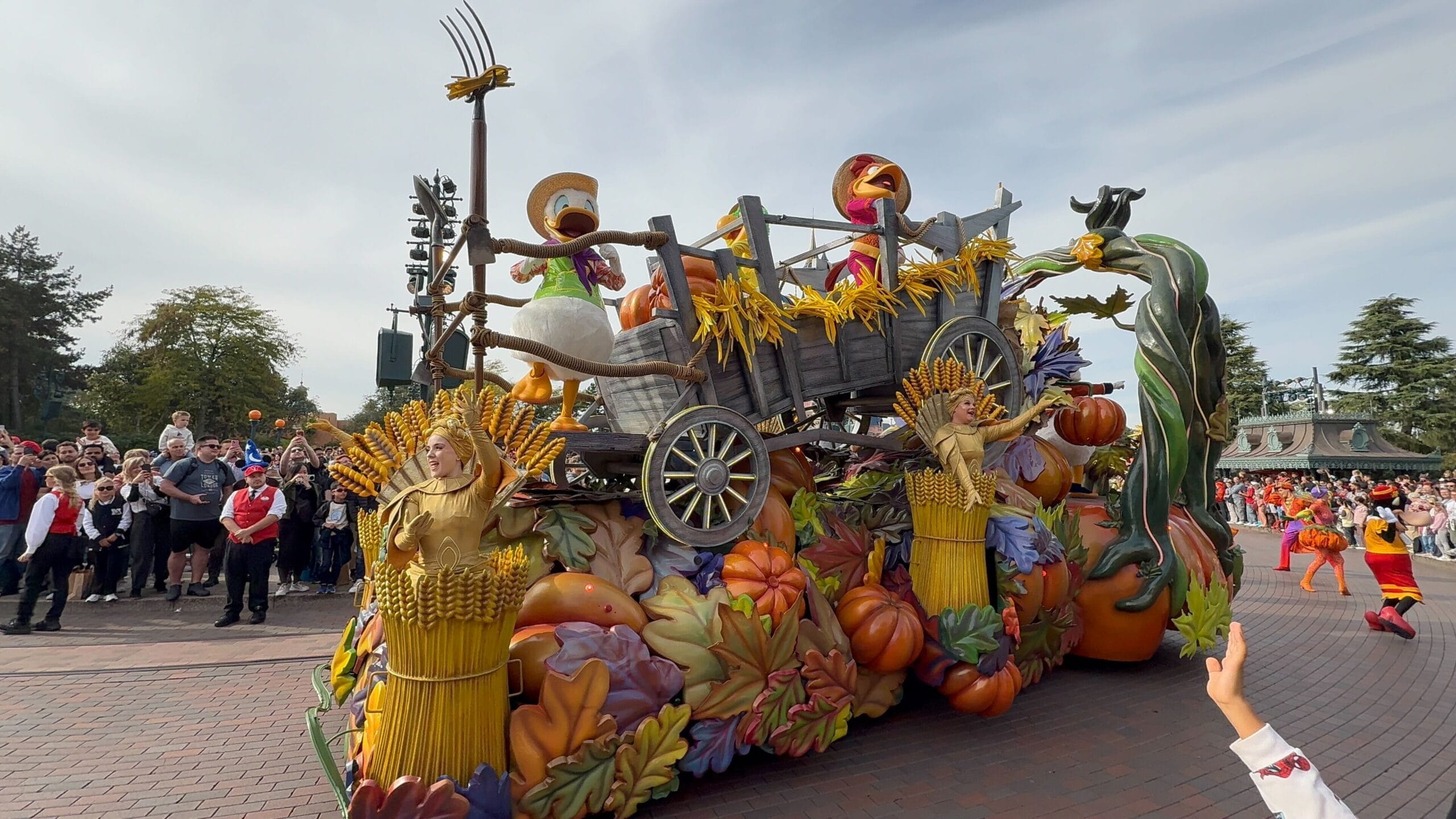 A colorful parade float at Disneyland Paris’s 2025 Mickey’s Halloween Celebration features cartoon ducks and golden wheat costumes.