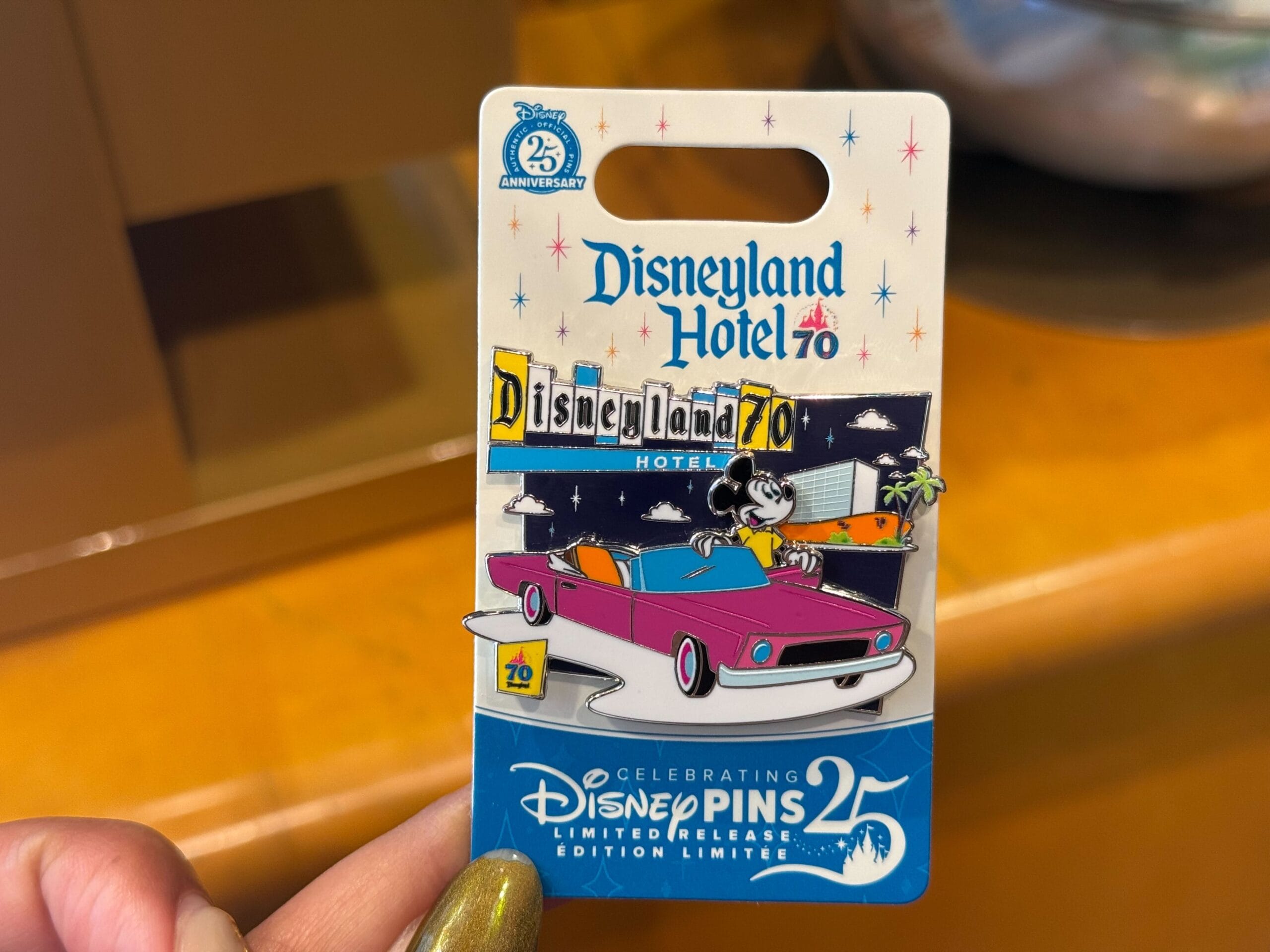 A Disneyland Hotel 70th Anniversary pin featuring Mickey Mouse in a pink car, part of the Anniversary Collection.