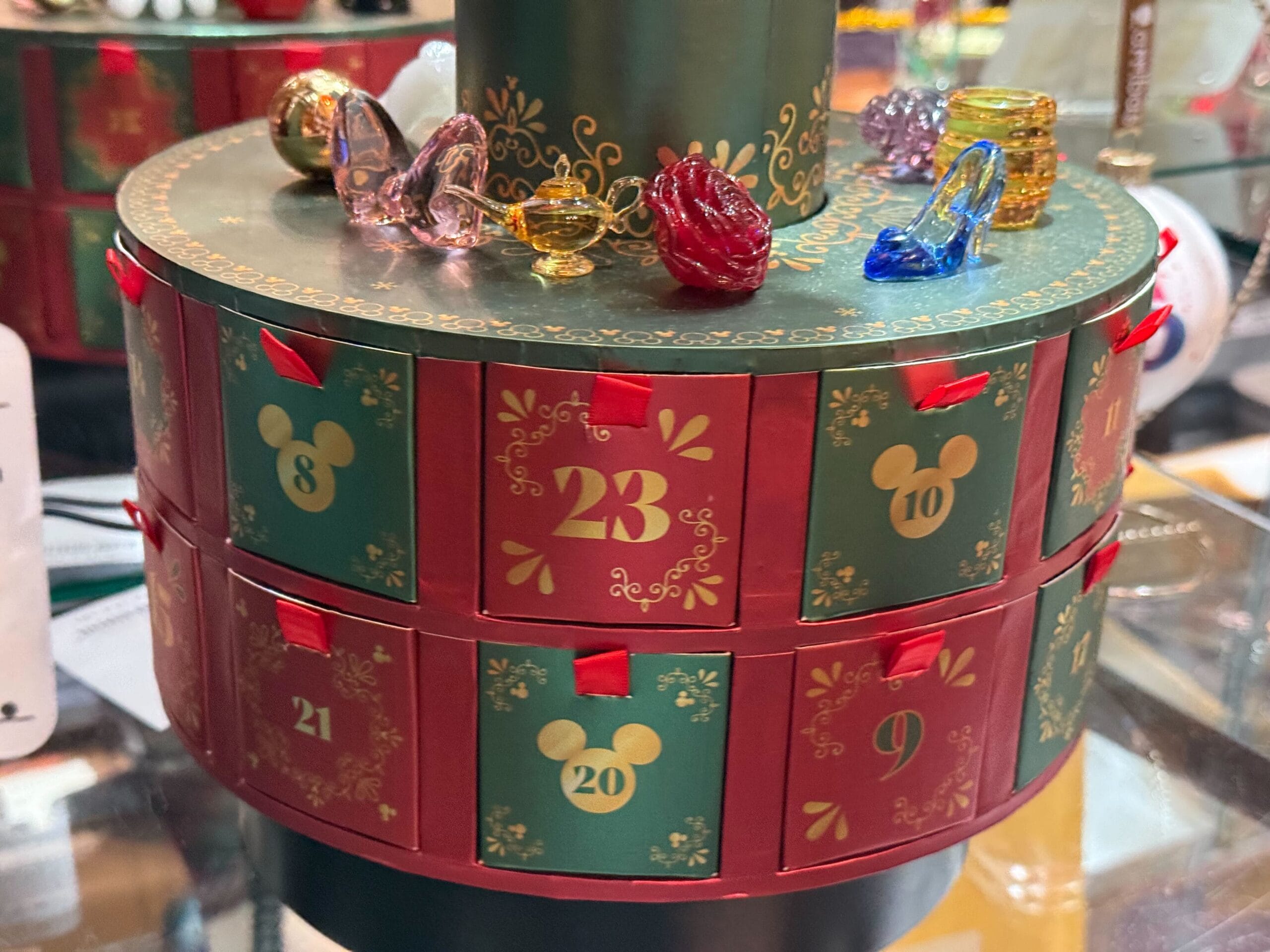A Disney Parks advent calendar with numbered drawers and glass figurines, some resembling iconic castles from various Disneyland resorts.