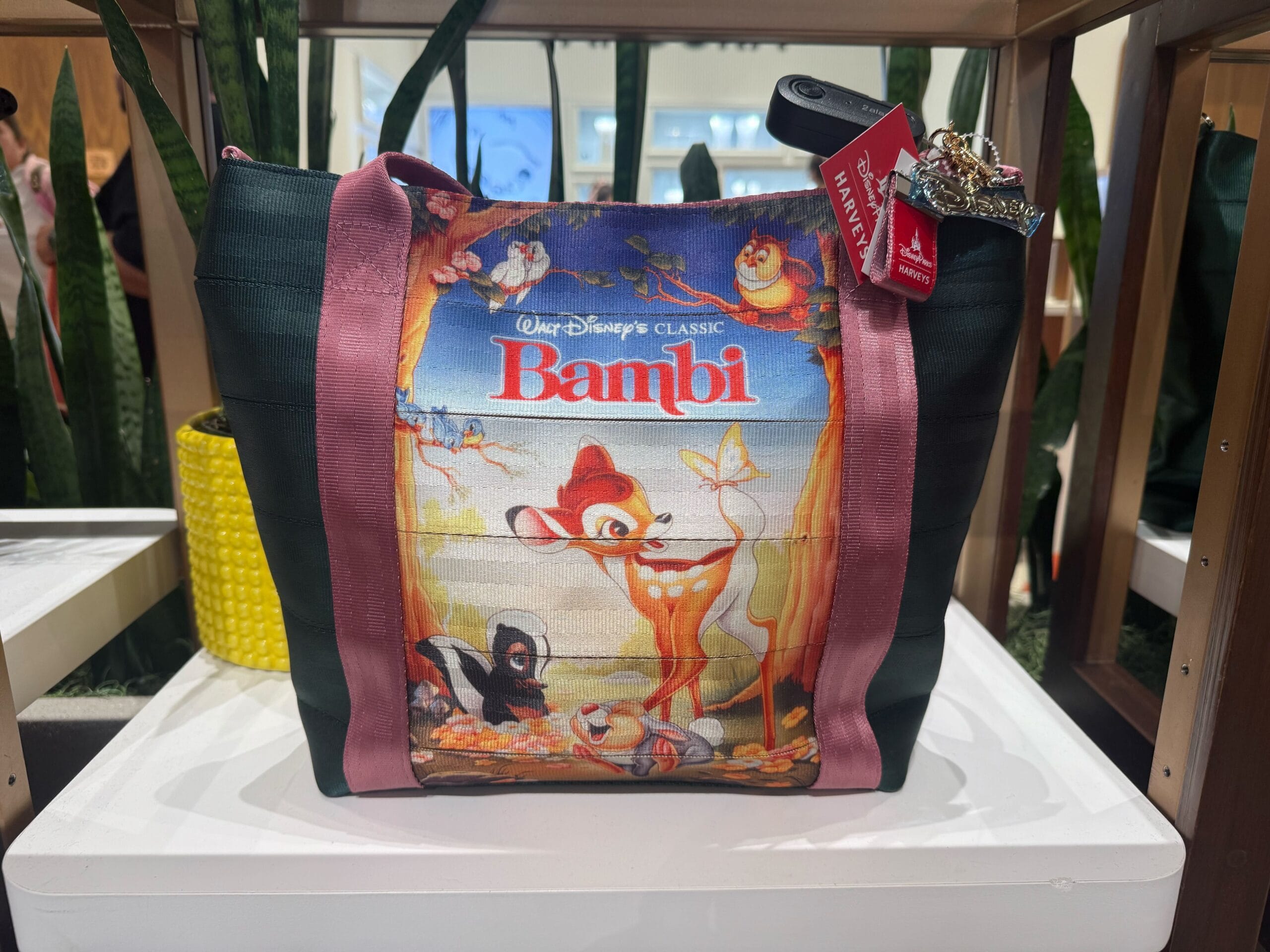 A tote bag with Disney’s Bambi movie poster art, displayed on a white table with plants, perfect for a day at any Disney park.