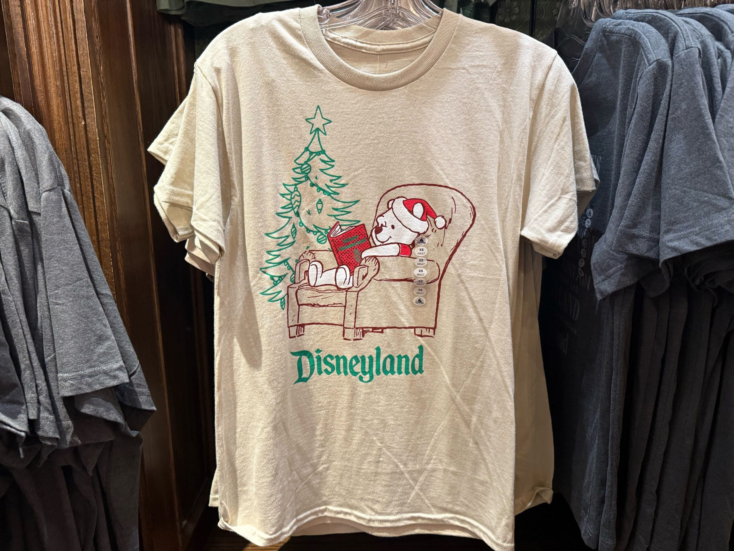 Beige Disneyland Christmas shirt with two bears by a tree—evokes classic Disney park holiday charm, perfect for 2025 gifting.