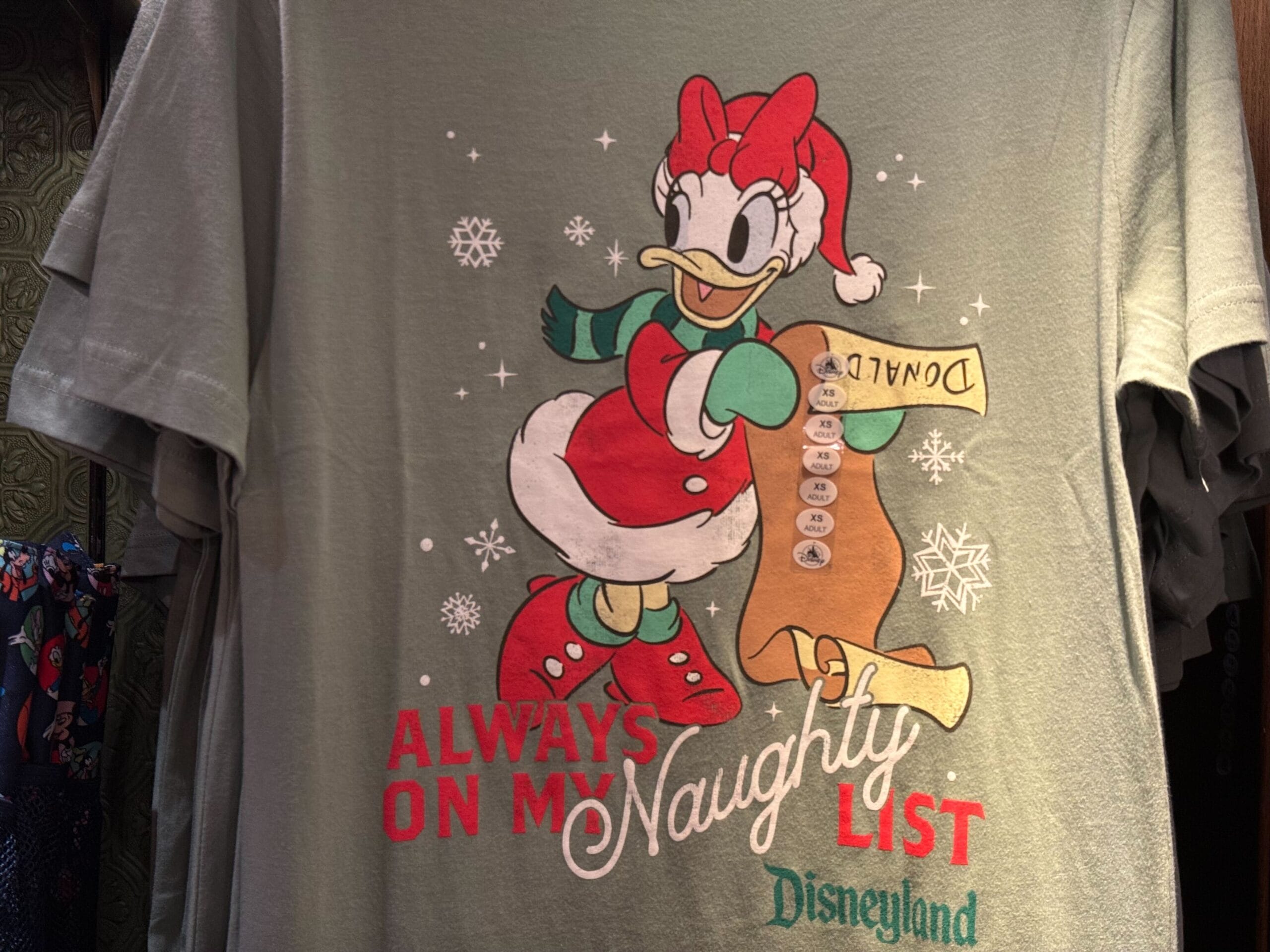 T-shirt with Daisy Duck in a Santa outfit, "Always on my naughty list." Fun Christmas Holiday Shirt. Disneyland.