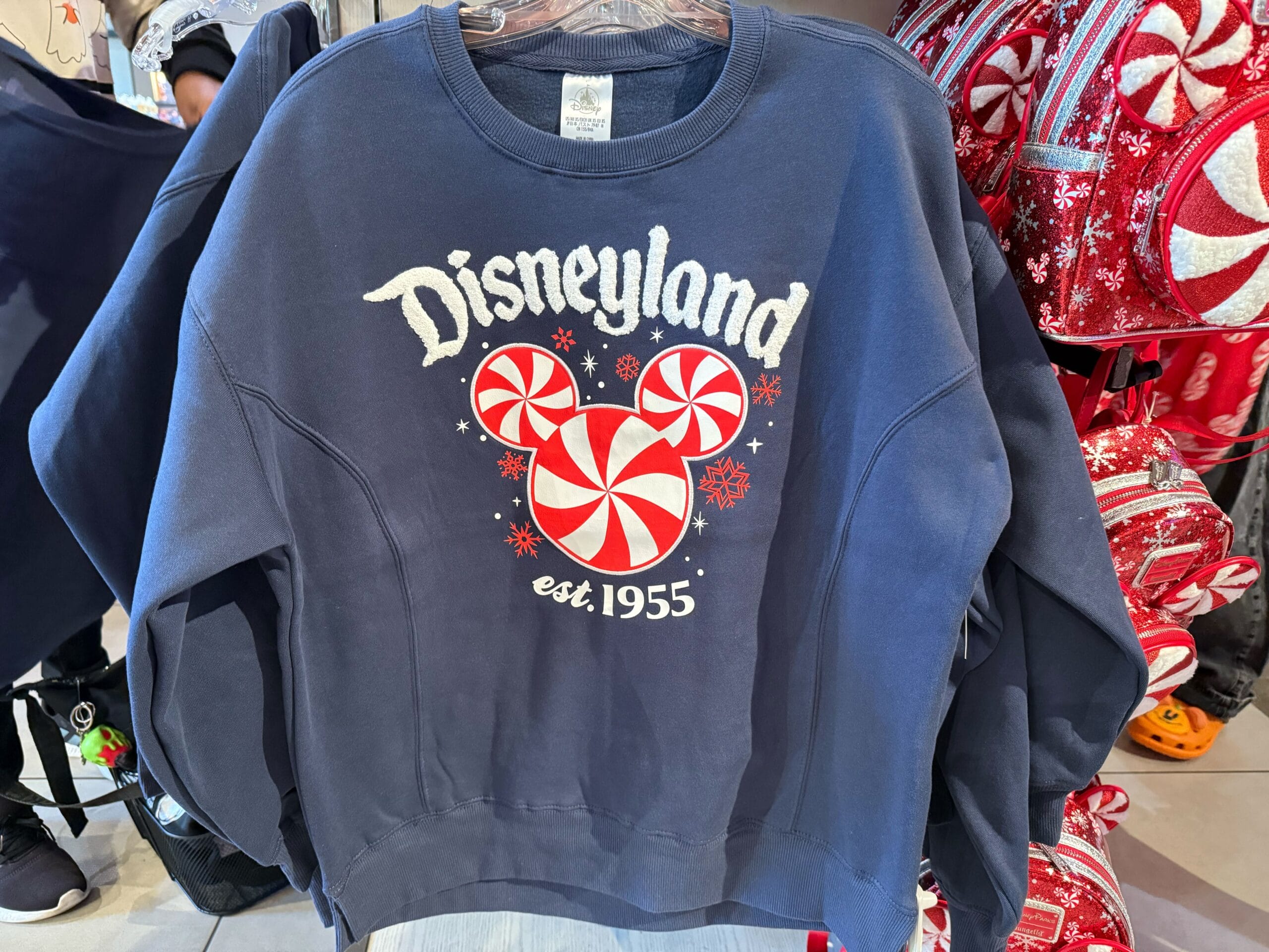 Navy blue Disneyland sweatshirt featuring a peppermint Mickey Mouse and "est. 1955"—the year Disneyland’s original castle opened.