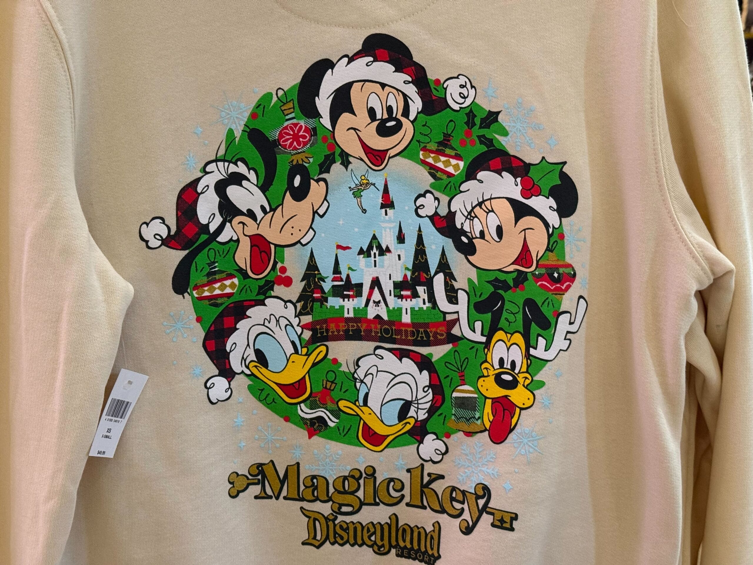Beige Disneyland Christmas sweatshirt with Mickey, Minnie, Goofy, Donald, and Pluto near a castle resembling Sleeping Beauty Castle.