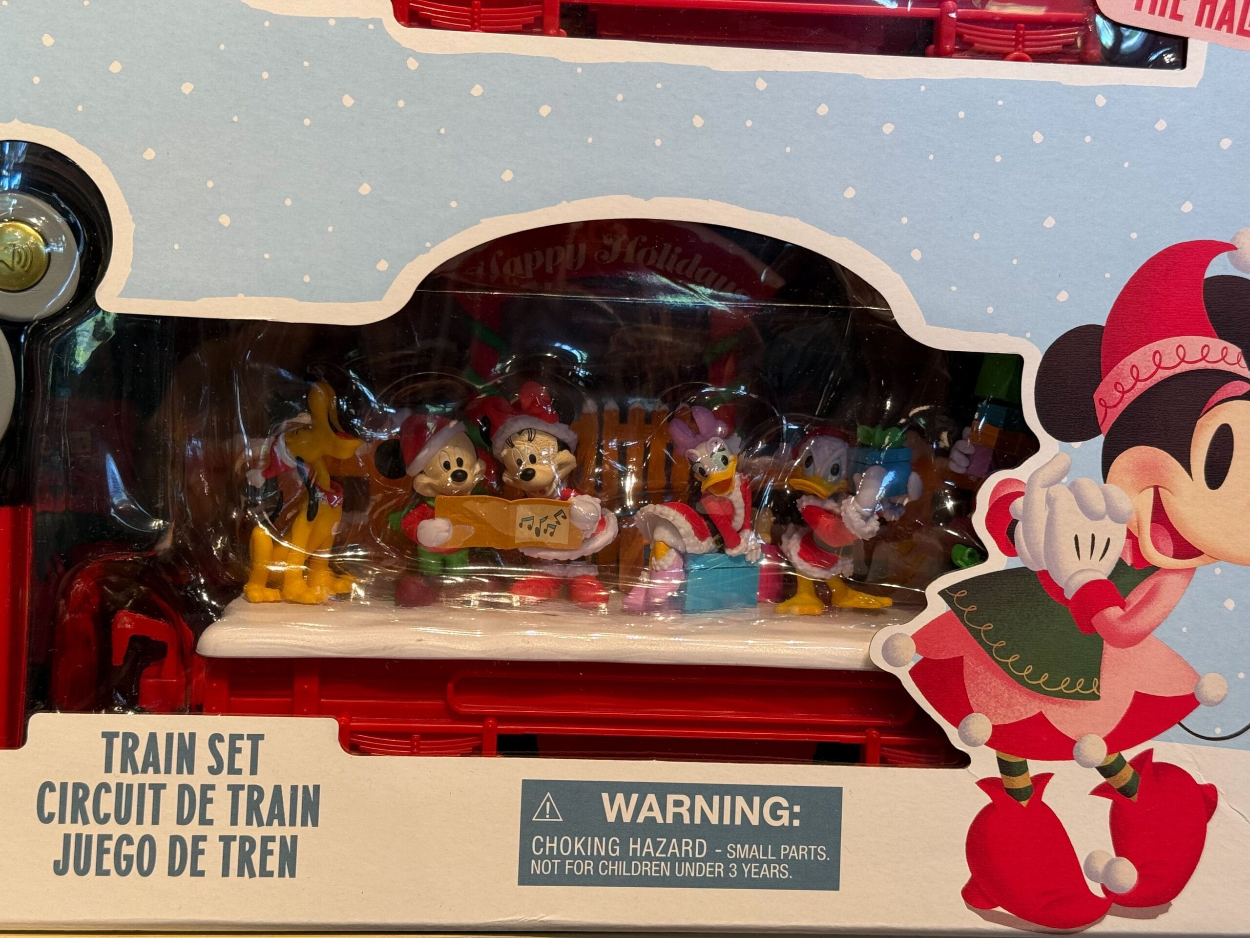 Disney Christmas train set box with caroling characters, reminiscent of park parades; small parts warning included.
