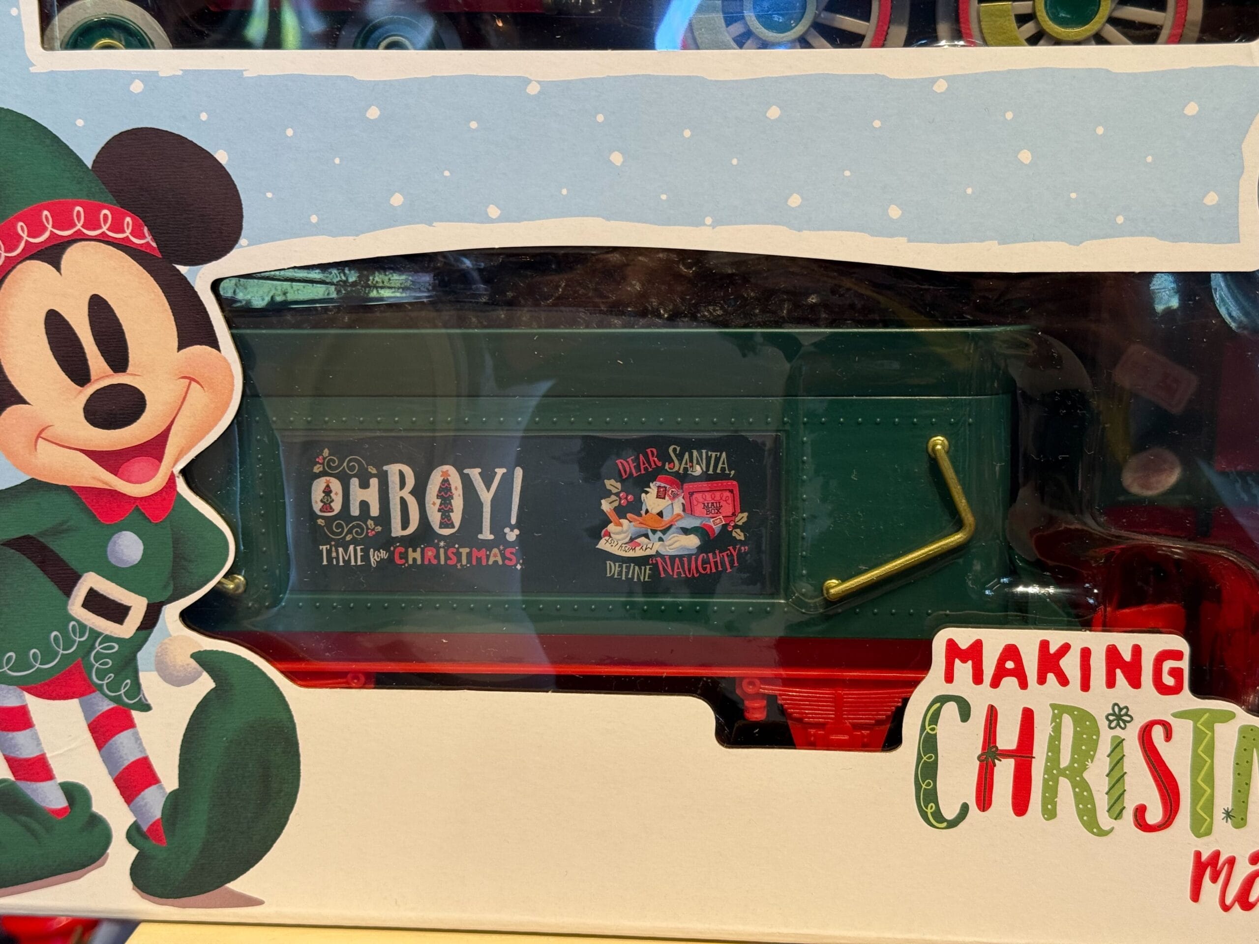 Disneyland Christmas train toy with Mickey Mouse, festive lettering, and exclusive park merchandise box; no castle present.
