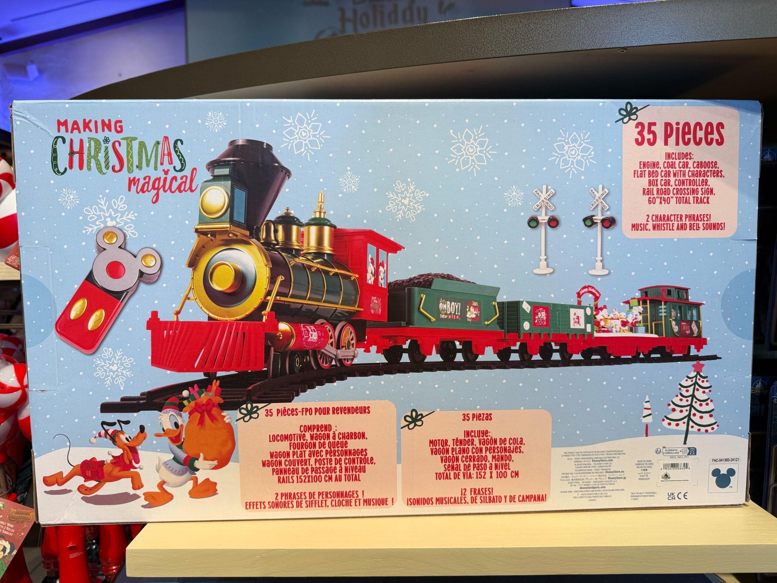 Box of a 35-piece Disney Christmas train set from the Peppermint Collection, with festive décor on snow, evoking park holiday magic.