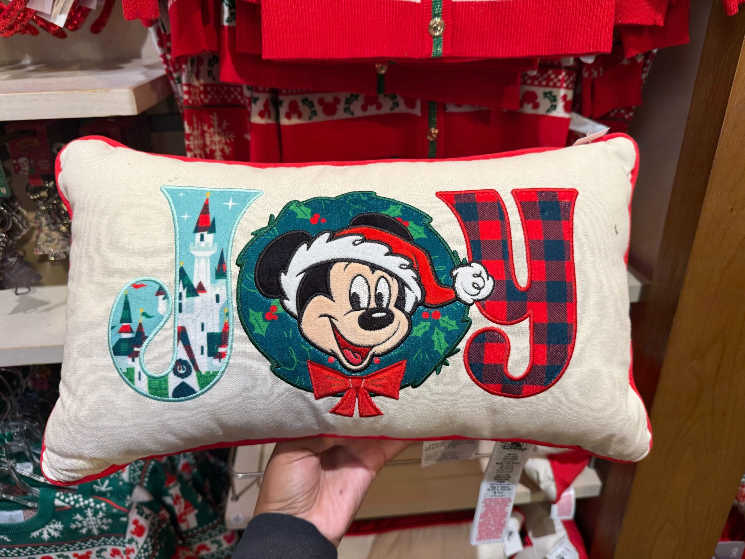 Peppermint Collection rectangular pillow with "JOY" and Mickey Mouse in a wreath—Disneyland holiday merchandise, no castle pictured.