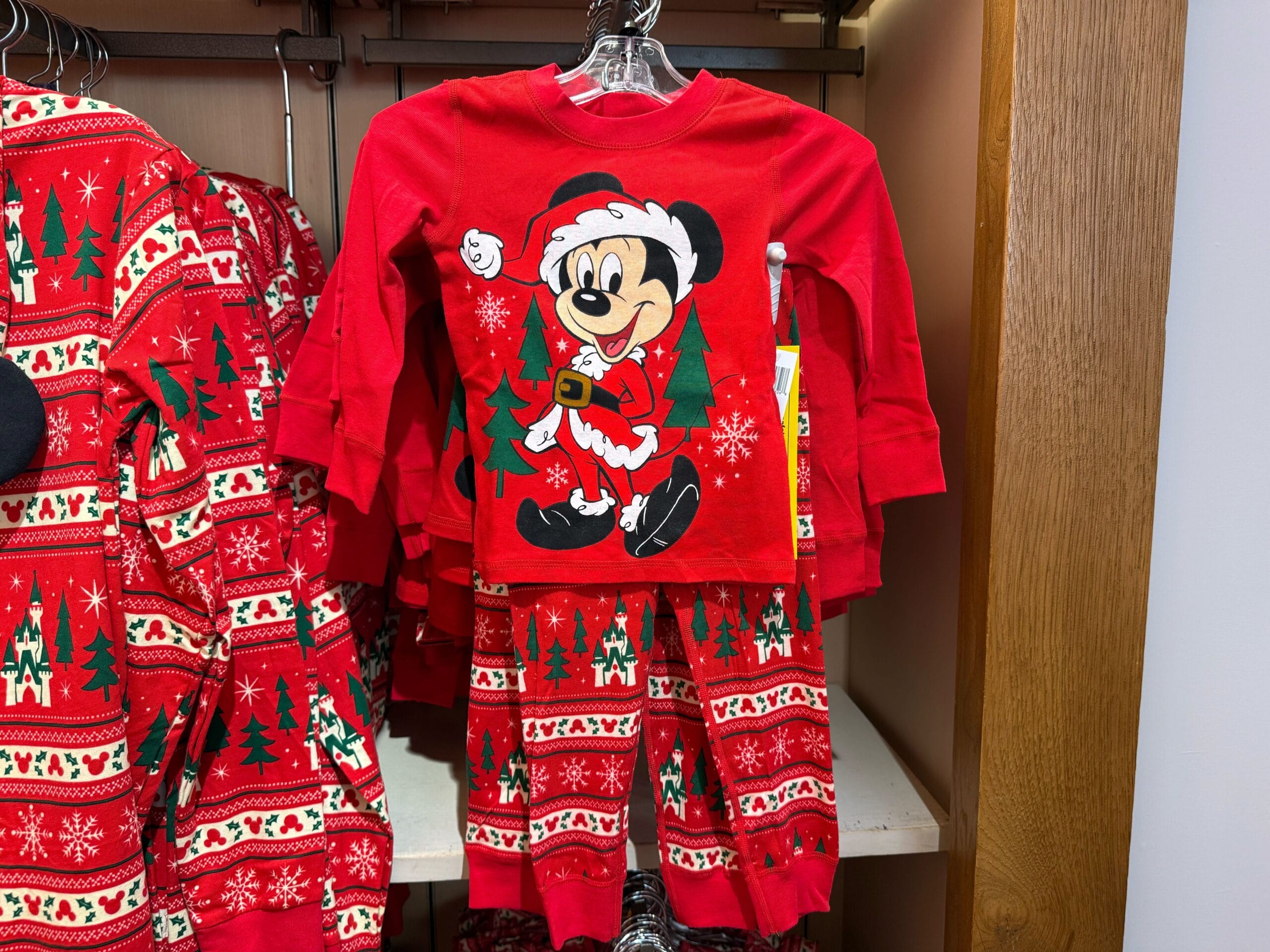 Red children's pajamas with Santa Mickey Mouse from the Peppermint Collection, seen in a store at a Disney park.