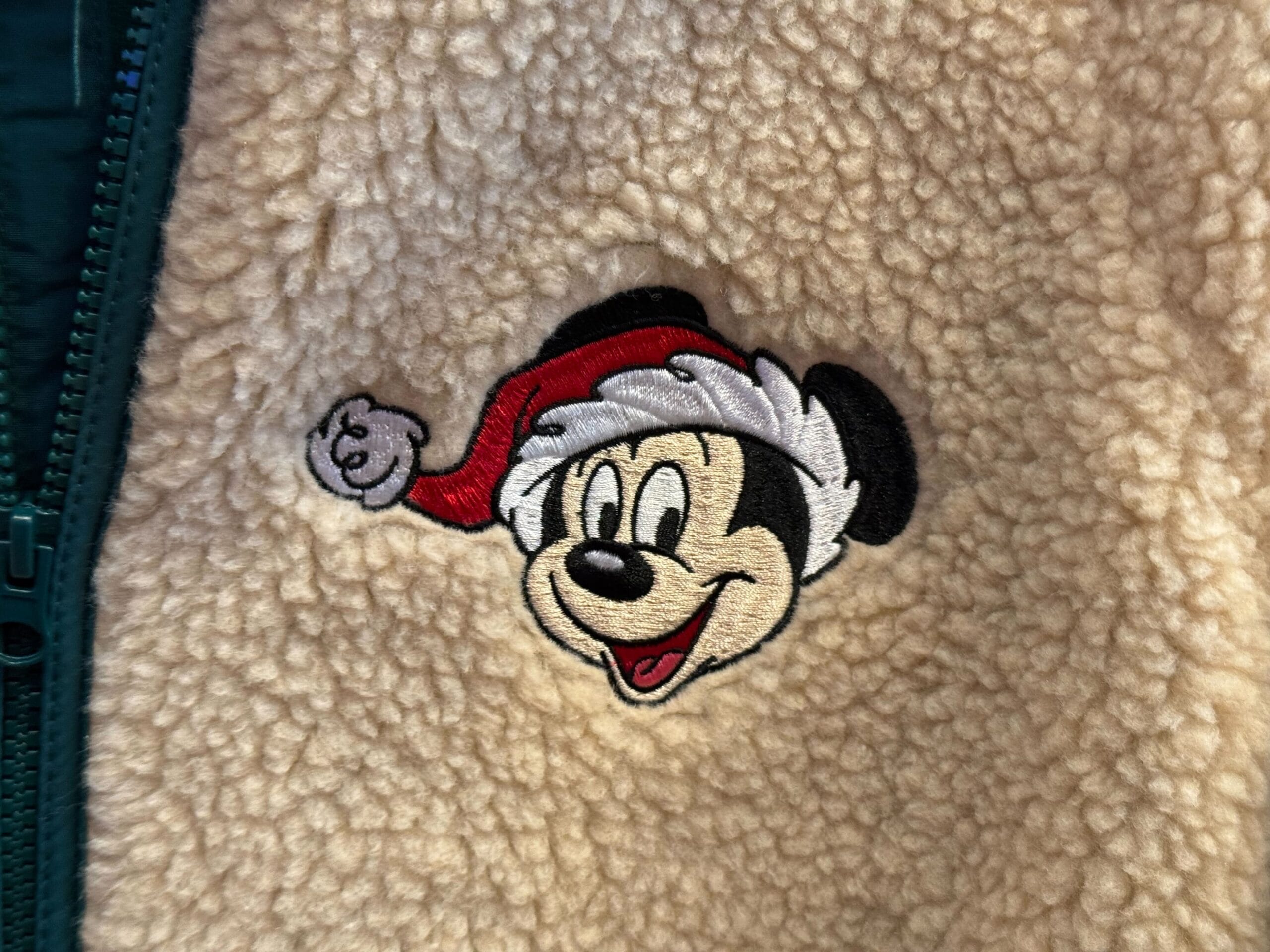 Mickey Mouse wearing a Santa hat embroidered on fuzzy fabric, part of Disneyland’s Peppermint Christmas Collection merchandise.