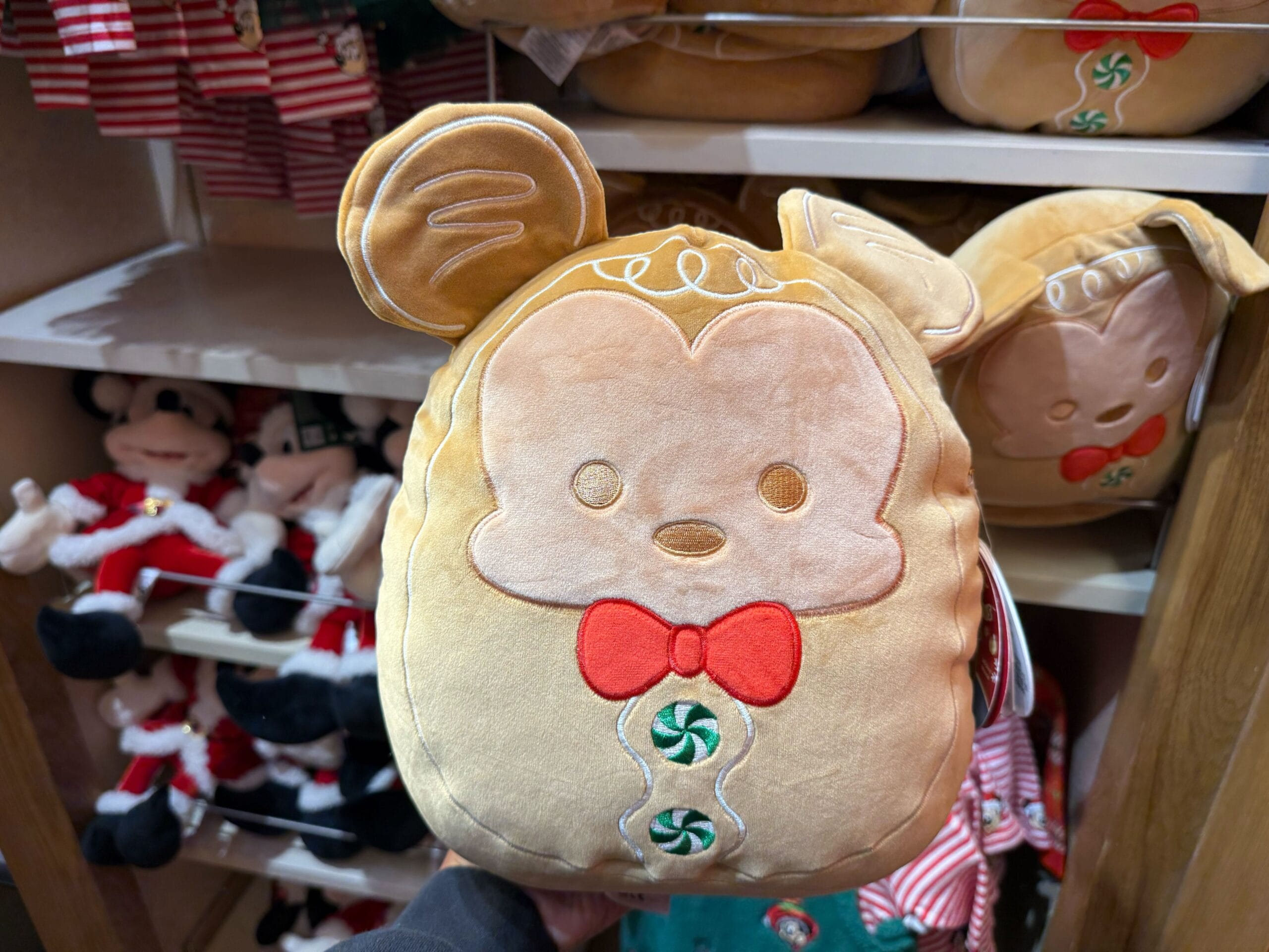 A plush gingerbread Mickey Mouse from Disneyland’s festive merch line, held in-store—no castle comparison shown in this image.