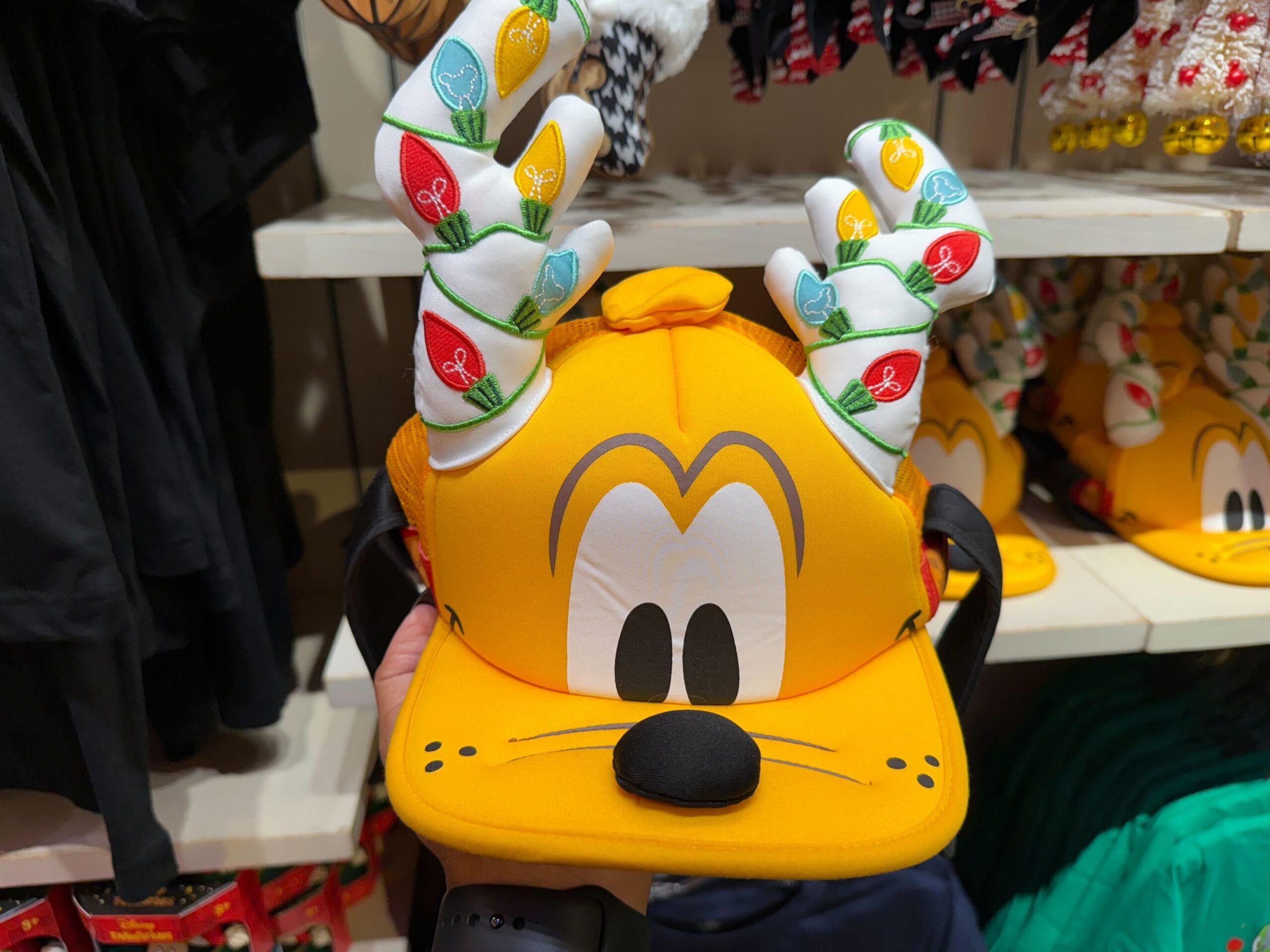 A yellow Pluto hat with antlers and festive lights, sold as Christmas merchandise at Disneyland Resort—no castle in this image.
