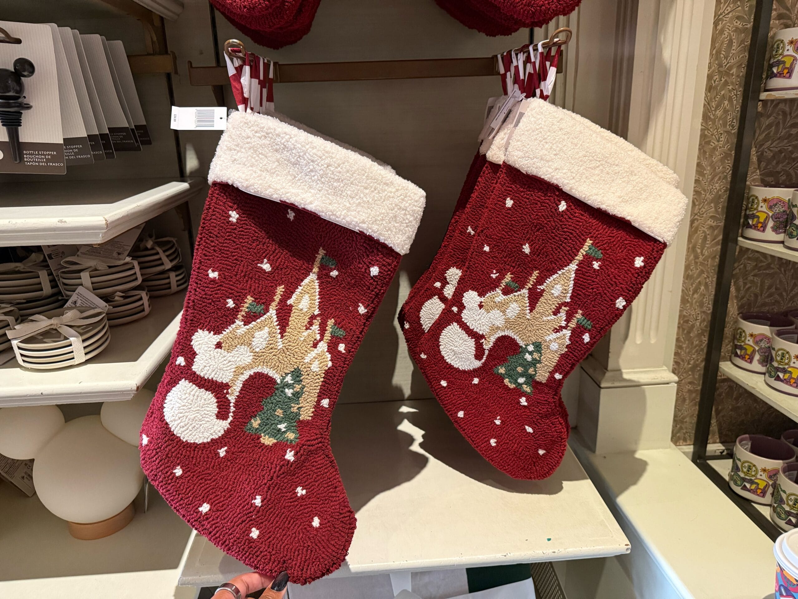 Two red stockings with reindeer and tree designs hang in Disneyland’s Christmas shop, near Sleeping Beauty Castle, unique to Anaheim.