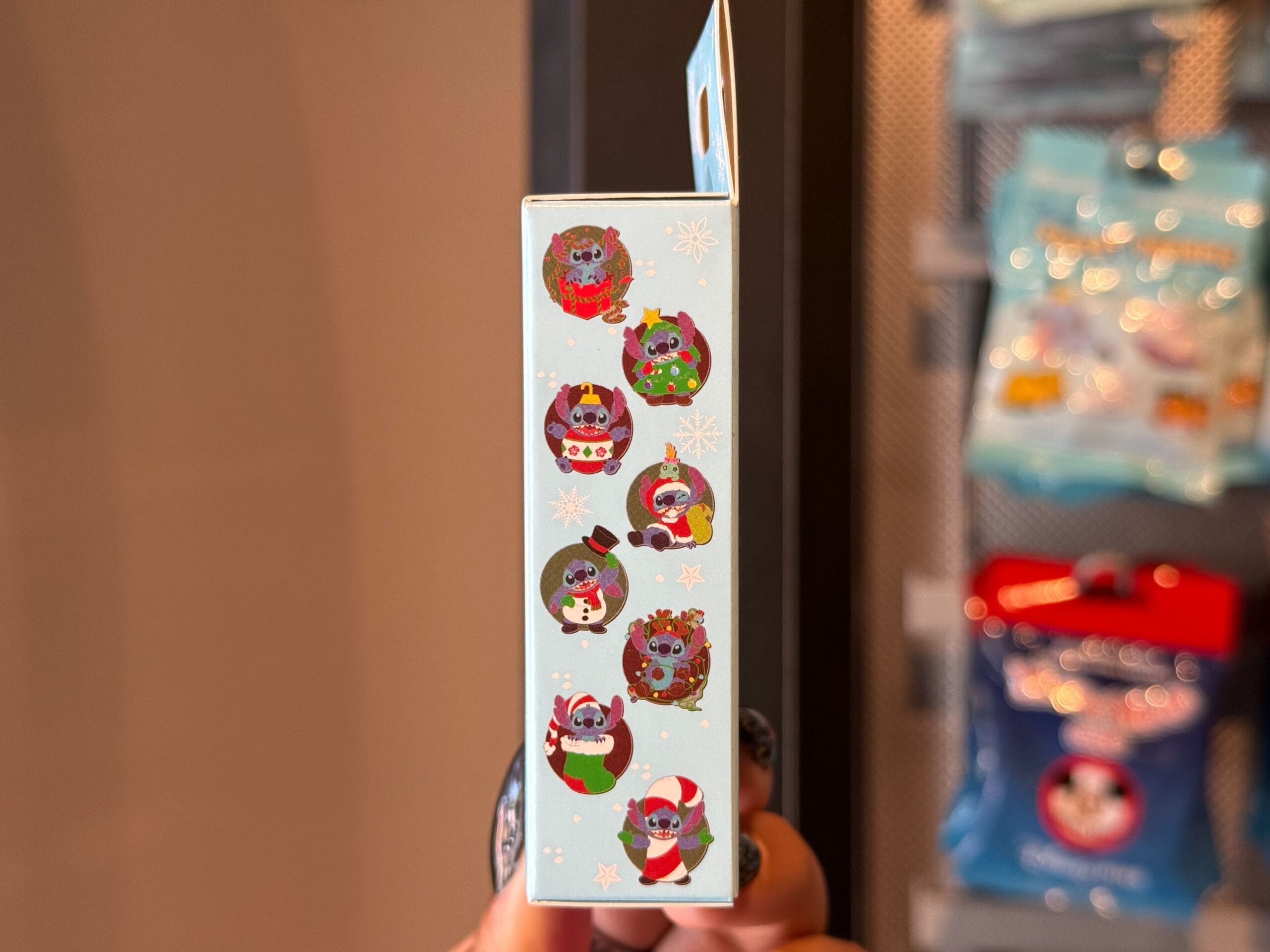 A box side features six vibrant Disney-style animals in festive attire with snowflakes, evoking classic Disneyland holiday merch.