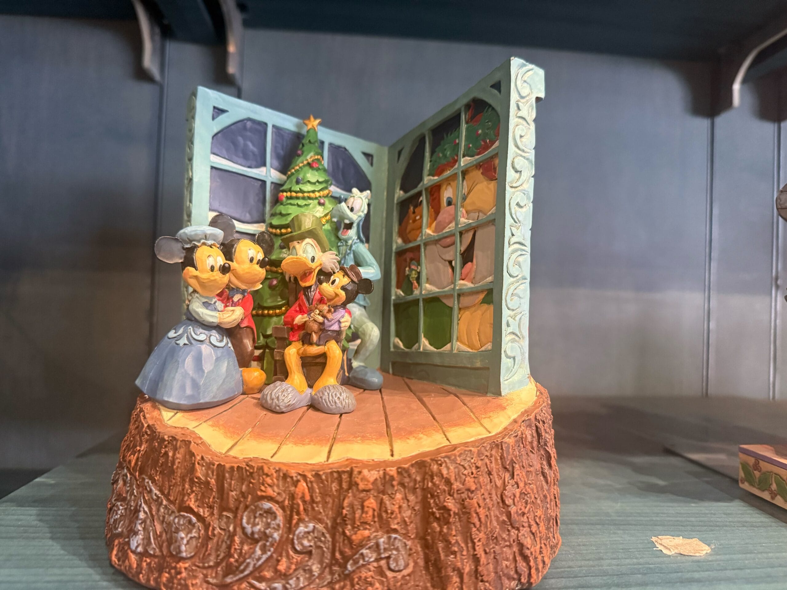 Disney characters celebrate Christmas by a tree, styled after Disneyland Resort decor—no castle in view to compare with global park castles.