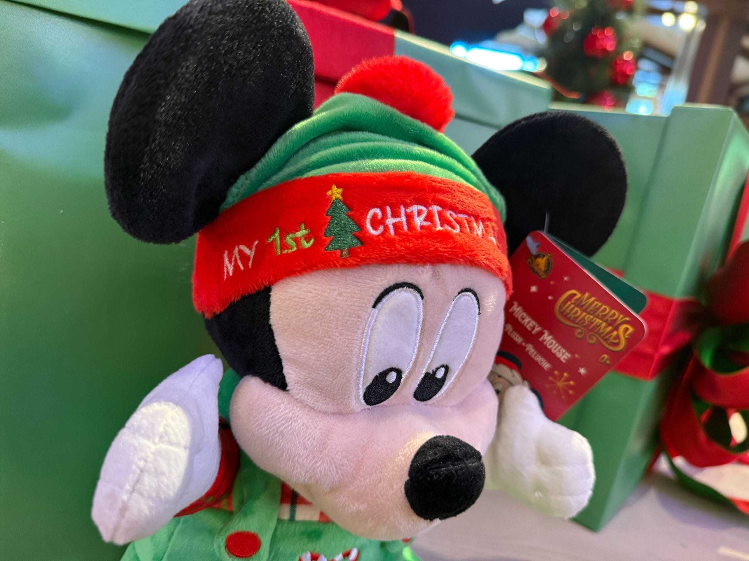 Plush Mickey Mouse in a "My 1st Christmas" hat, part of Disneyland Resort holiday merchandise, no castle pictured to compare.