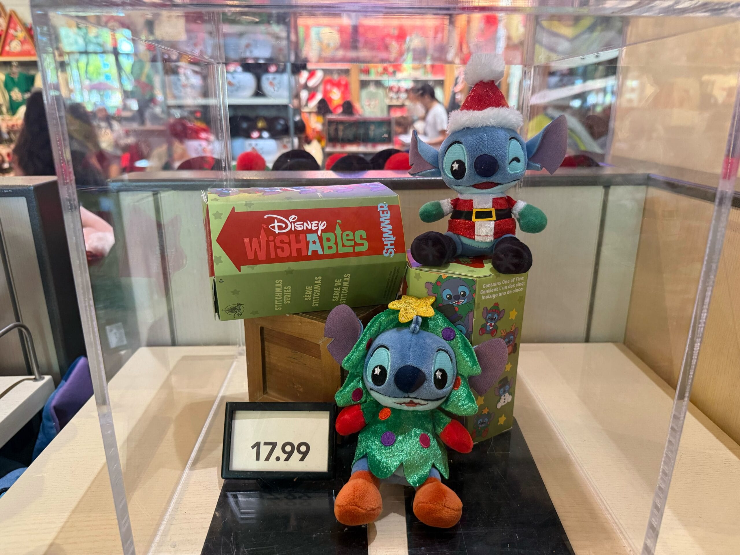 Two Stitch plush toys in festive attire with a Wishables box, new at Disneyland Resort for $17.99 among holiday merchandise.