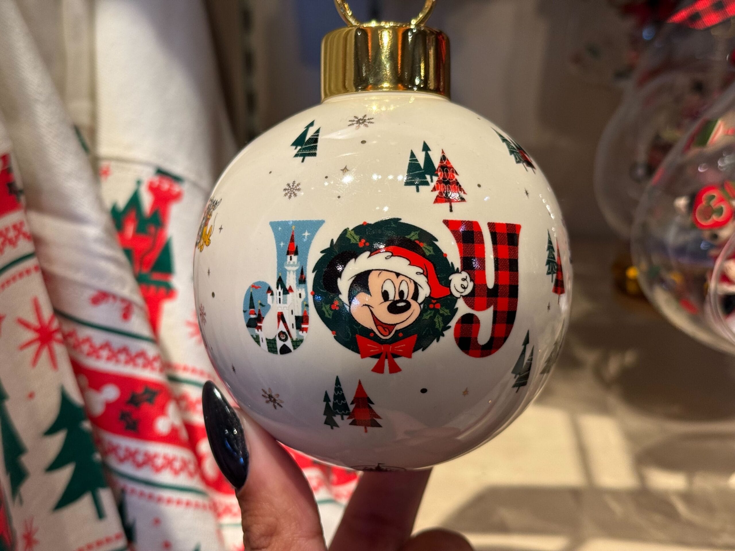 White ornament reading "JOY" with Mickey in a Santa hat—new Disneyland Resort holiday merch, exclusive to California, not WDW.