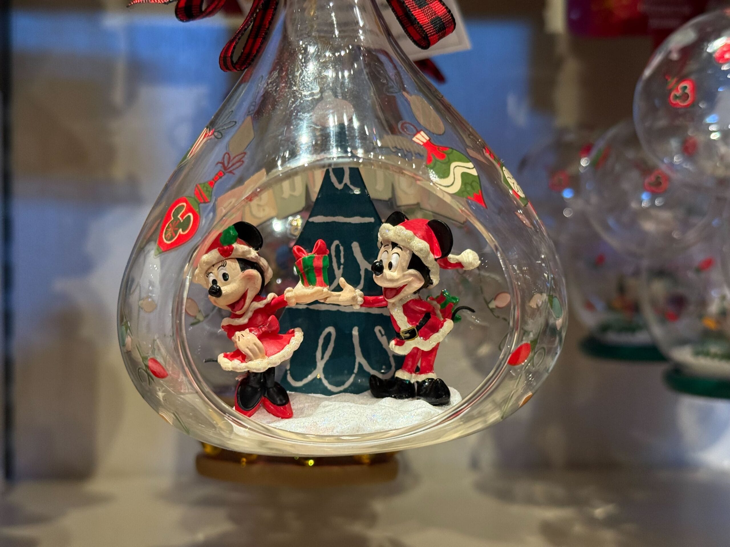 Glass ornament from our New Arrivals with Minnie and Mickey in Santa outfits, perfect Disney Parks Christmas merchandise.