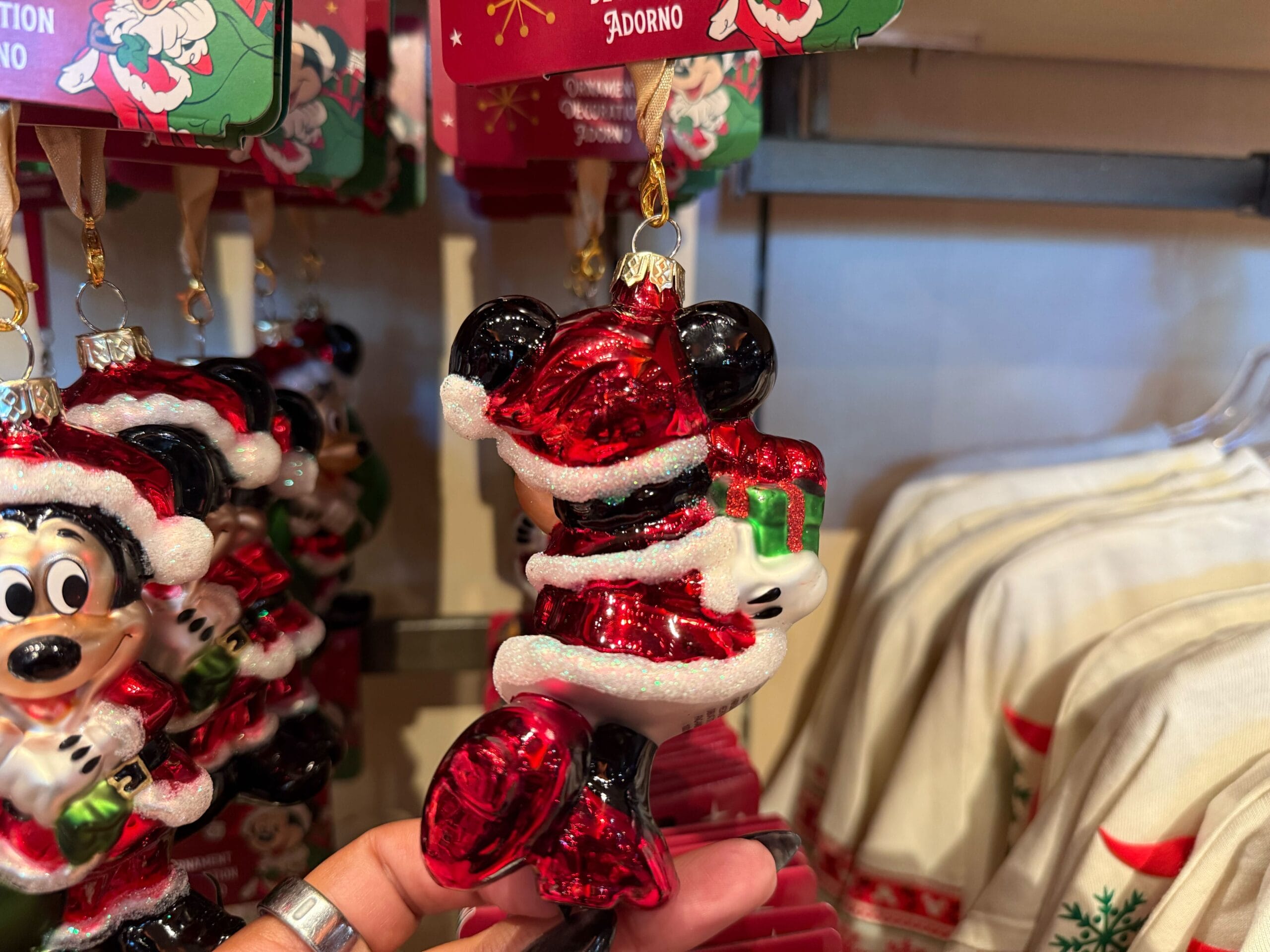 A Mickey Mouse ornament in a Santa suit with a green present, part of Disneyland Resort holiday merchandise—no castle shown here.
