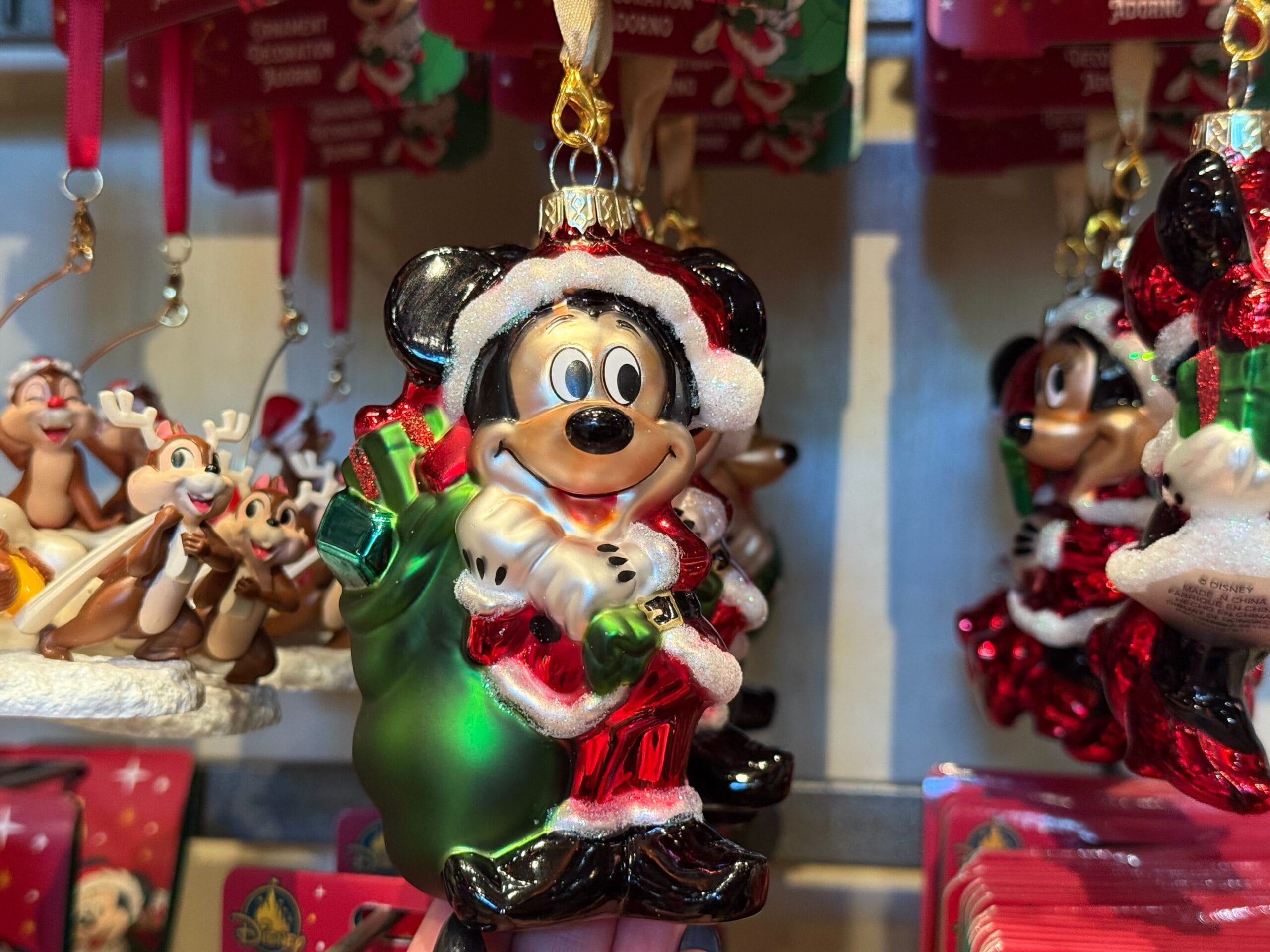 A Disneyland Resort Christmas ornament of Mickey Mouse as Santa hangs festively, unique to Disneyland compared to Disney World’s décor.