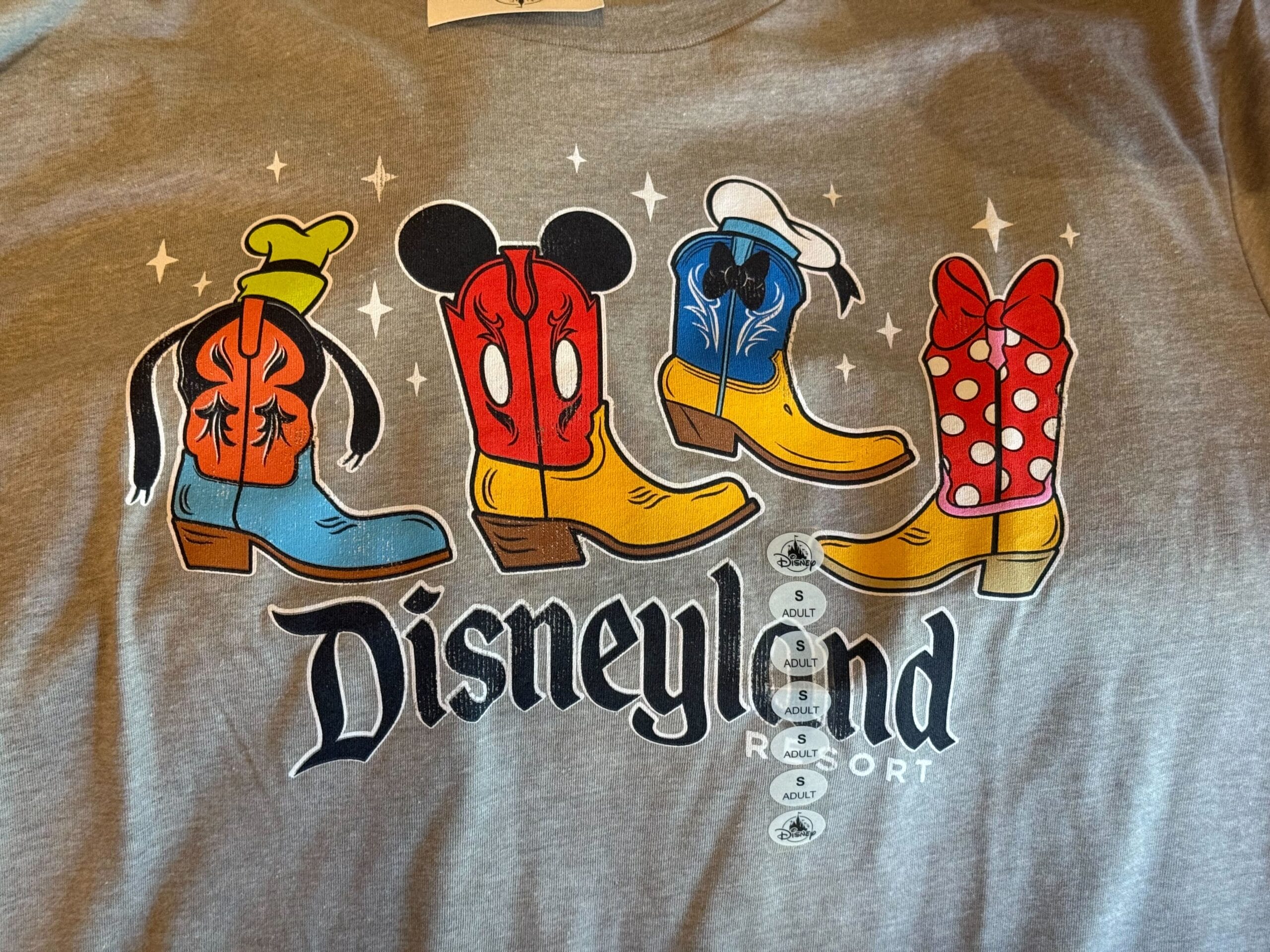 Four cowboy boots styled as Disney characters above "Disneyland Resort"—a fun Cowboy Boots Shirt for any fan.