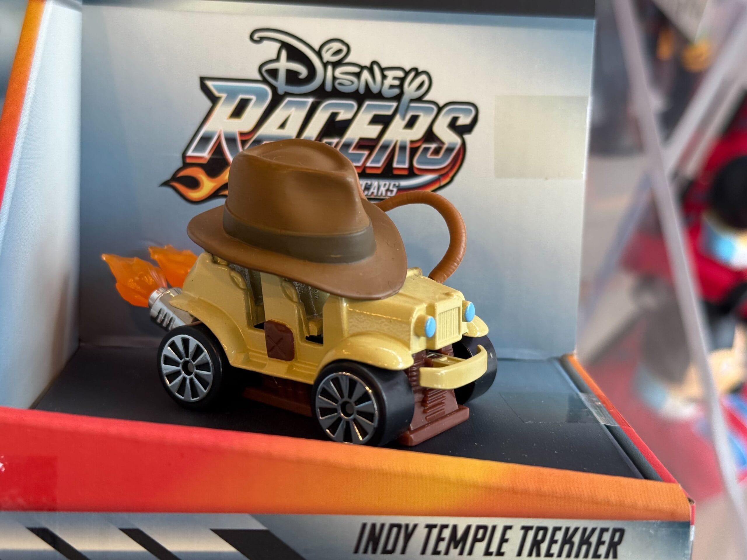 A Disney Racers car labeled "Indy Temple Trekker" from Disneyland, featuring a brown hat and flame details, reminiscent of Indy rides.