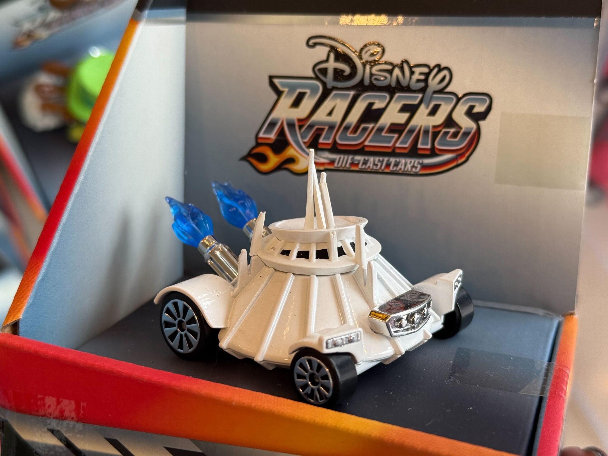A Disney Racers die-cast car styled as a Star Wars Star Destroyer, white with blue thrusters, sold in Disney park shops worldwide.