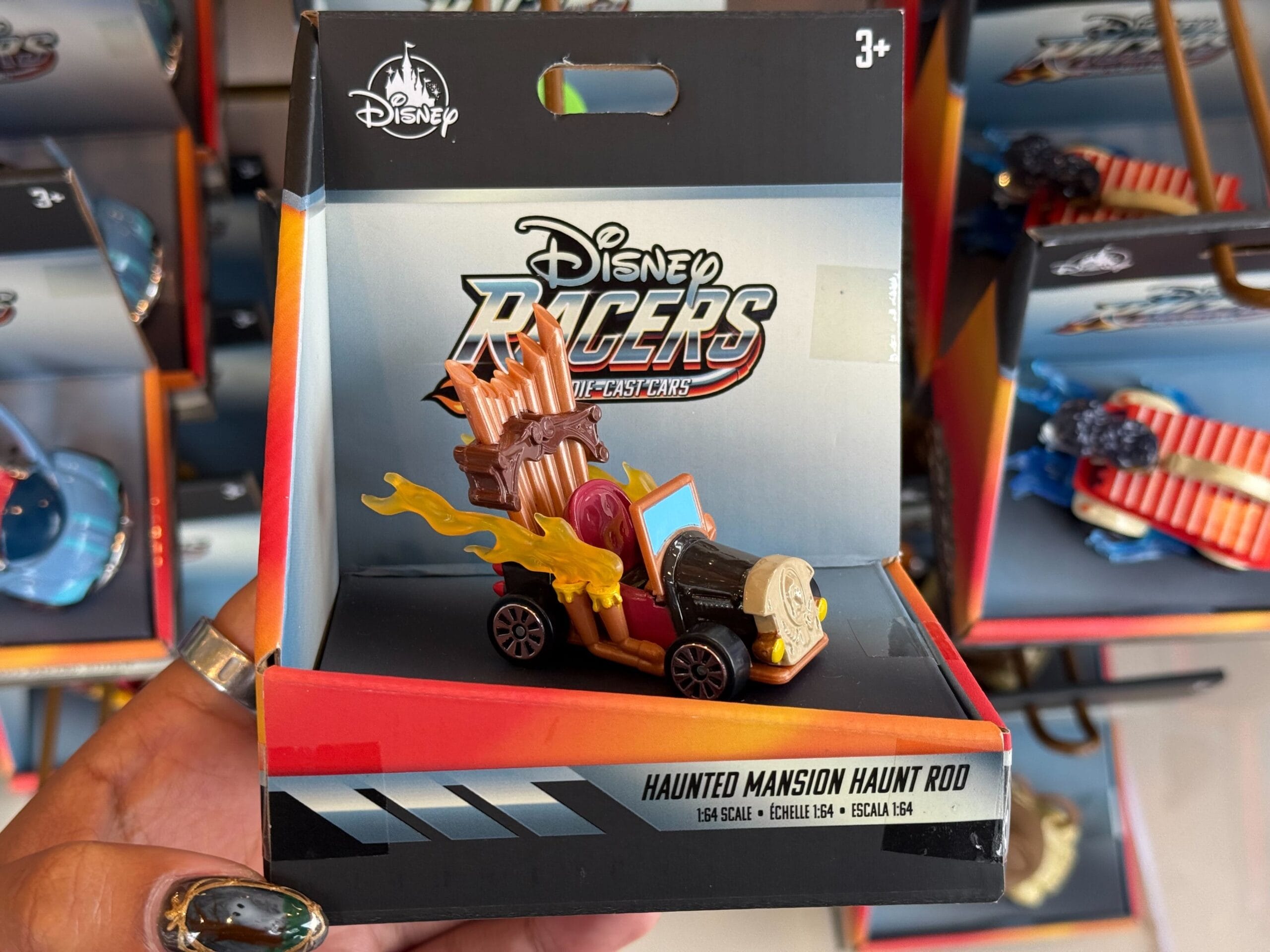 Disney Racers "Haunted Mansion Haunt Rod" toy car, featuring flames, skull, and organ pipes, in Disneyland park packaging.