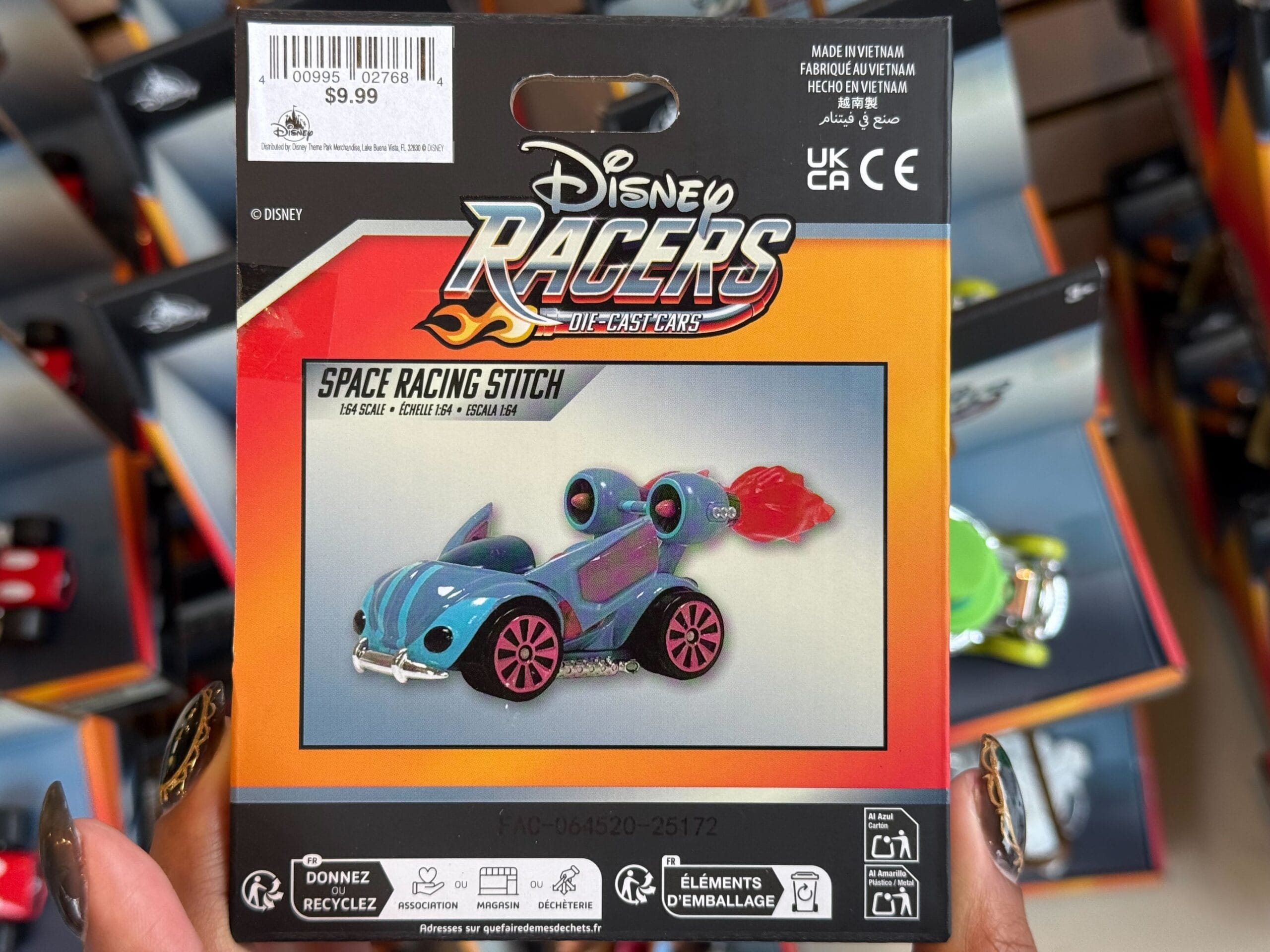 A Disney Racers "Space Racing Stitch" racecar toy, packaged and priced at $9.99, on display in a Disney park store.