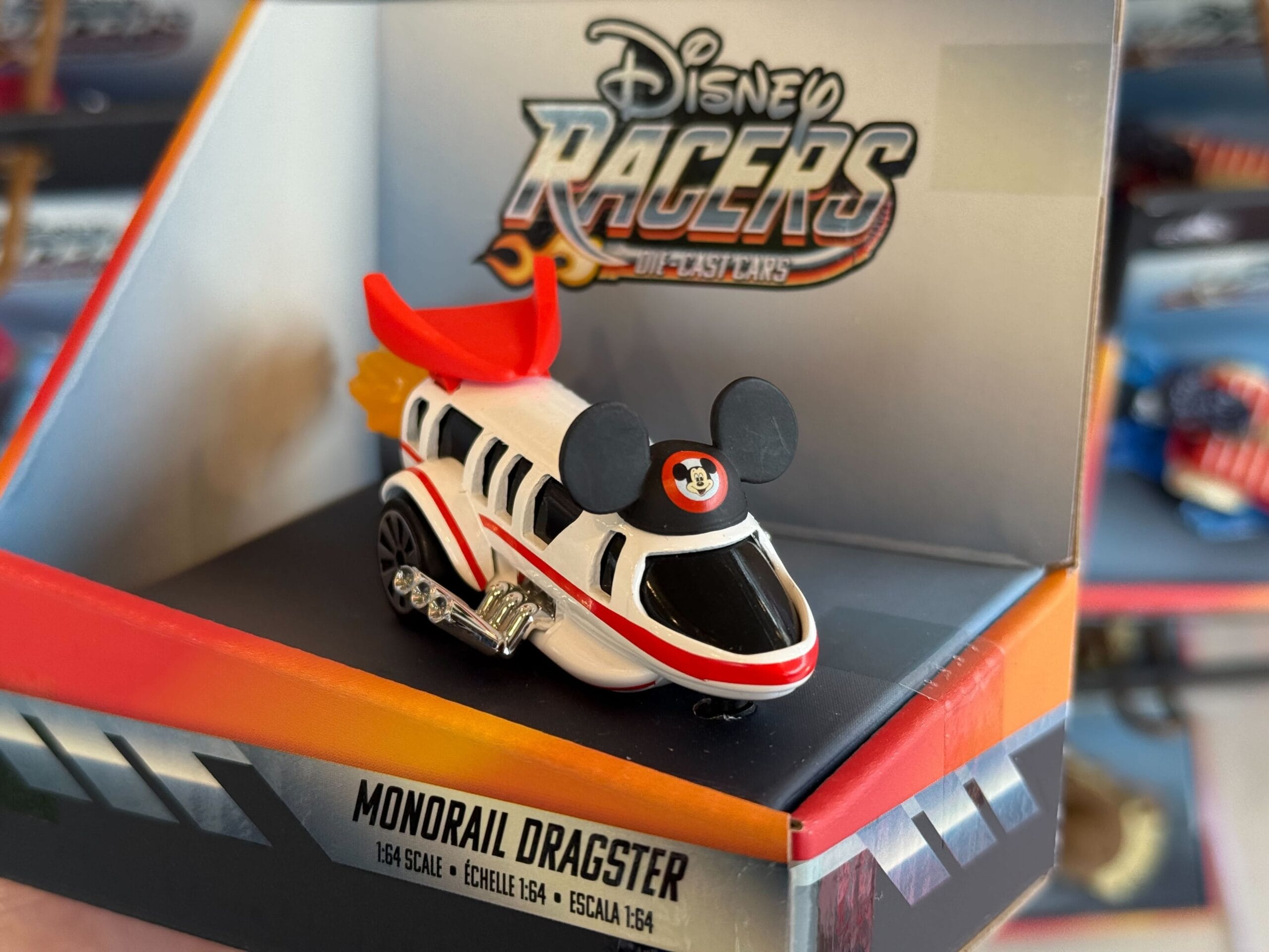A Disney Parks Racers Monorail Dragster toy with Mickey Mouse ears is packaged, reminiscent of Disneyland Resort exclusives.