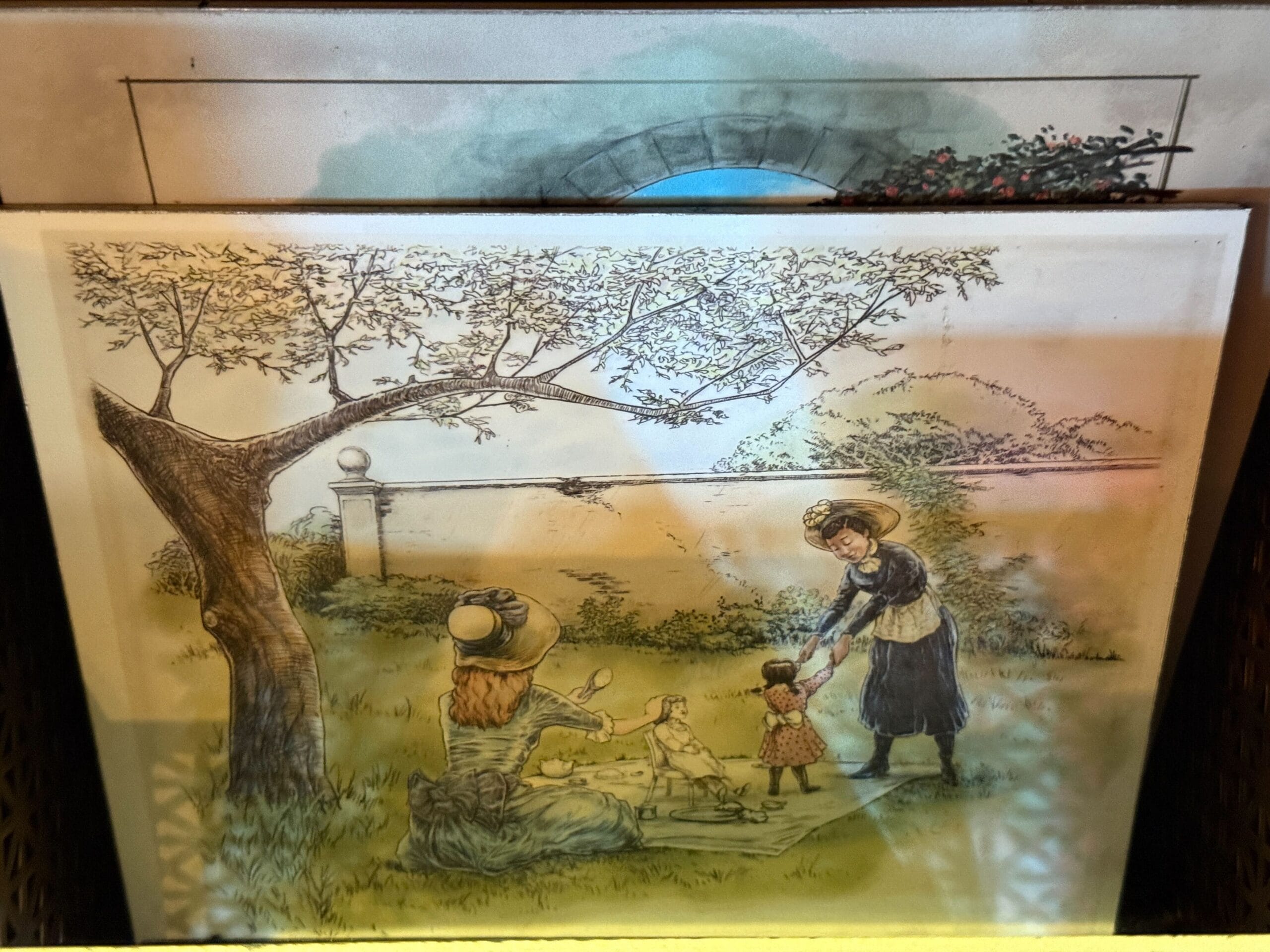A vintage scene of two women and two children enjoying a picnic under a garden tree, evoking classic Disney park nostalgia.