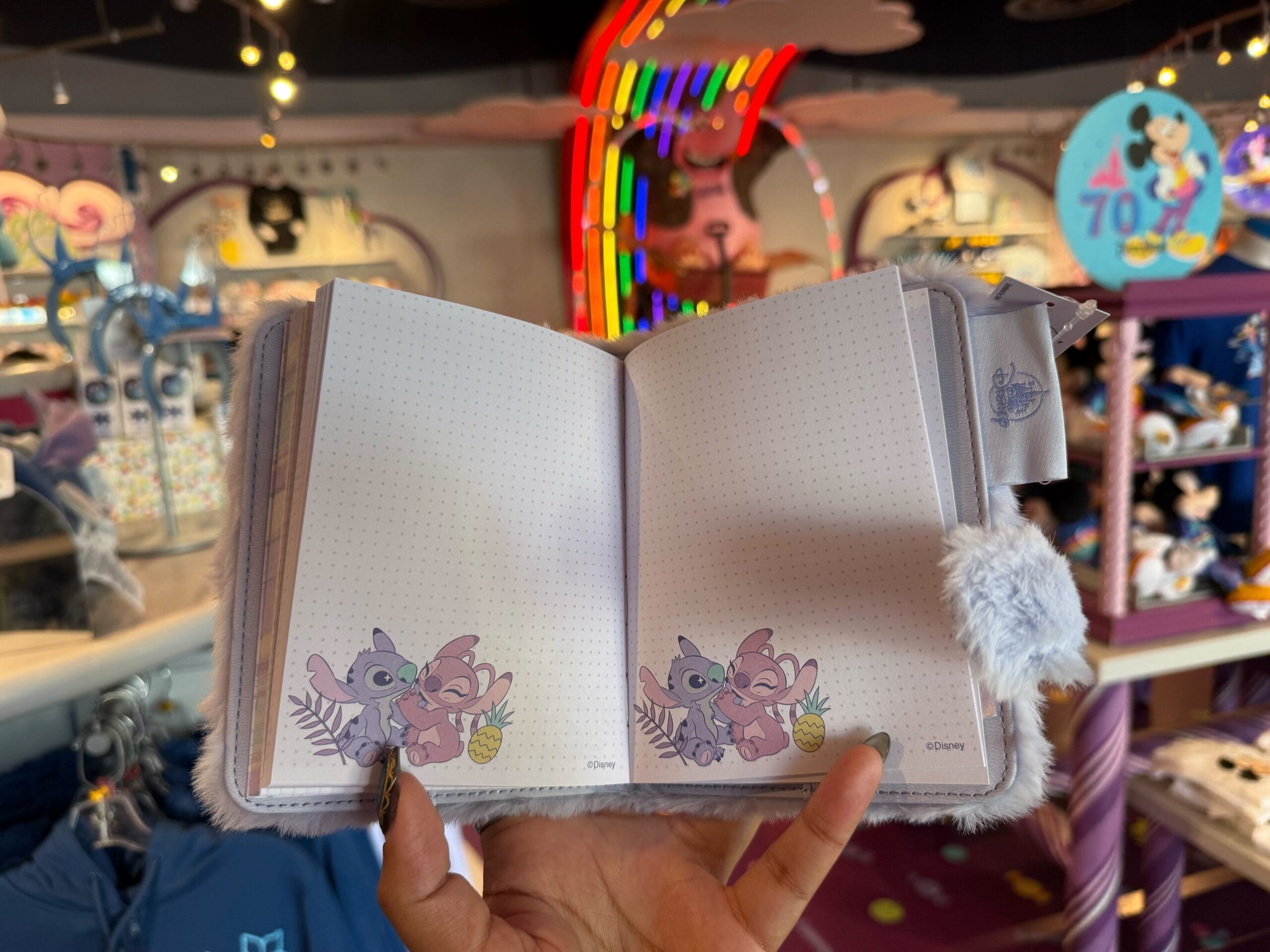 Open notebook with pastel Stitch and Angel art, reminiscent of Disneyland merchandise—ideal as a fluffy Stitch memory journal.