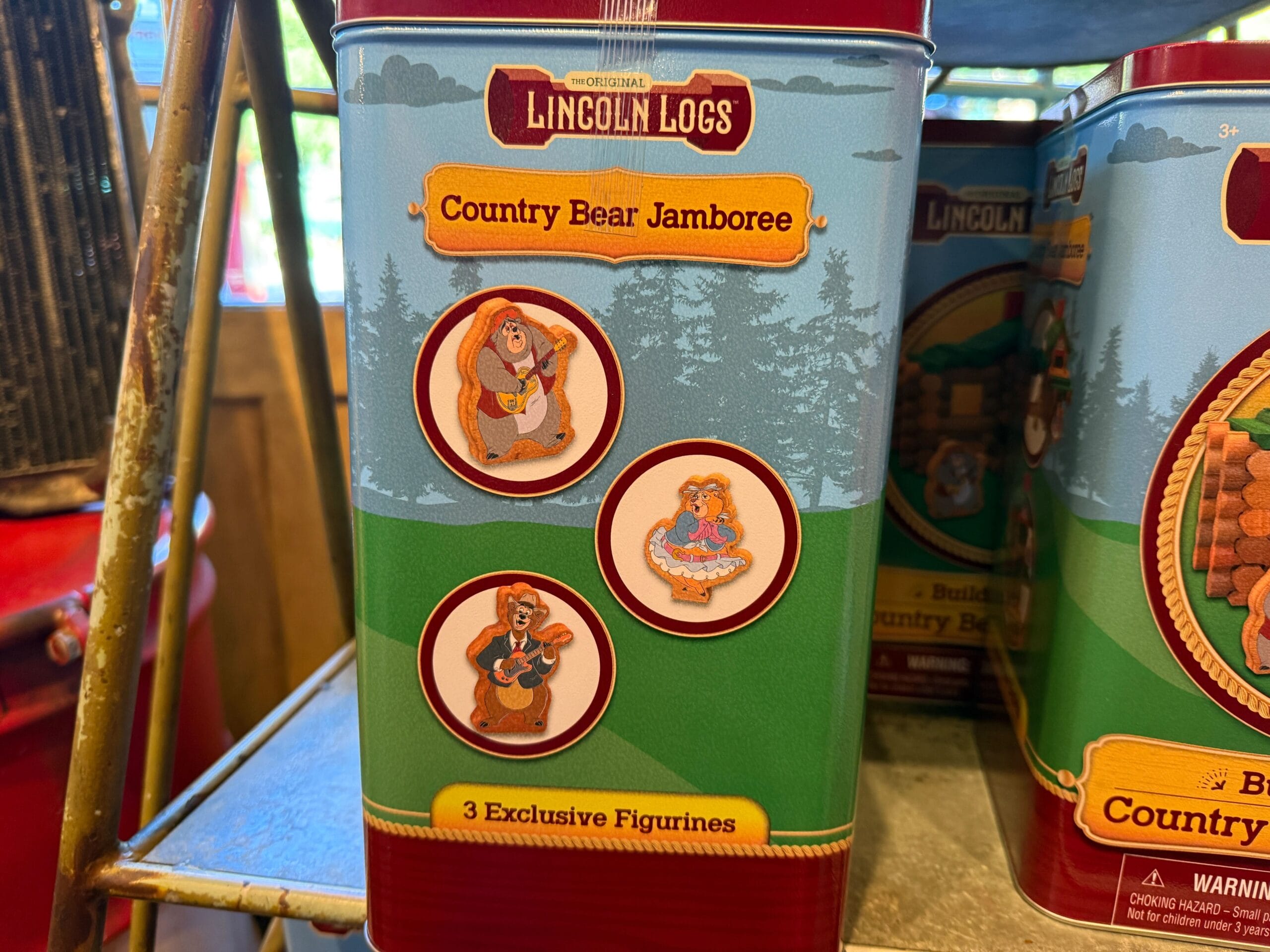 A tin of Lincoln Logs featuring Country Bear Jamboree and images of three exclusive Country Bears figurines on the front.