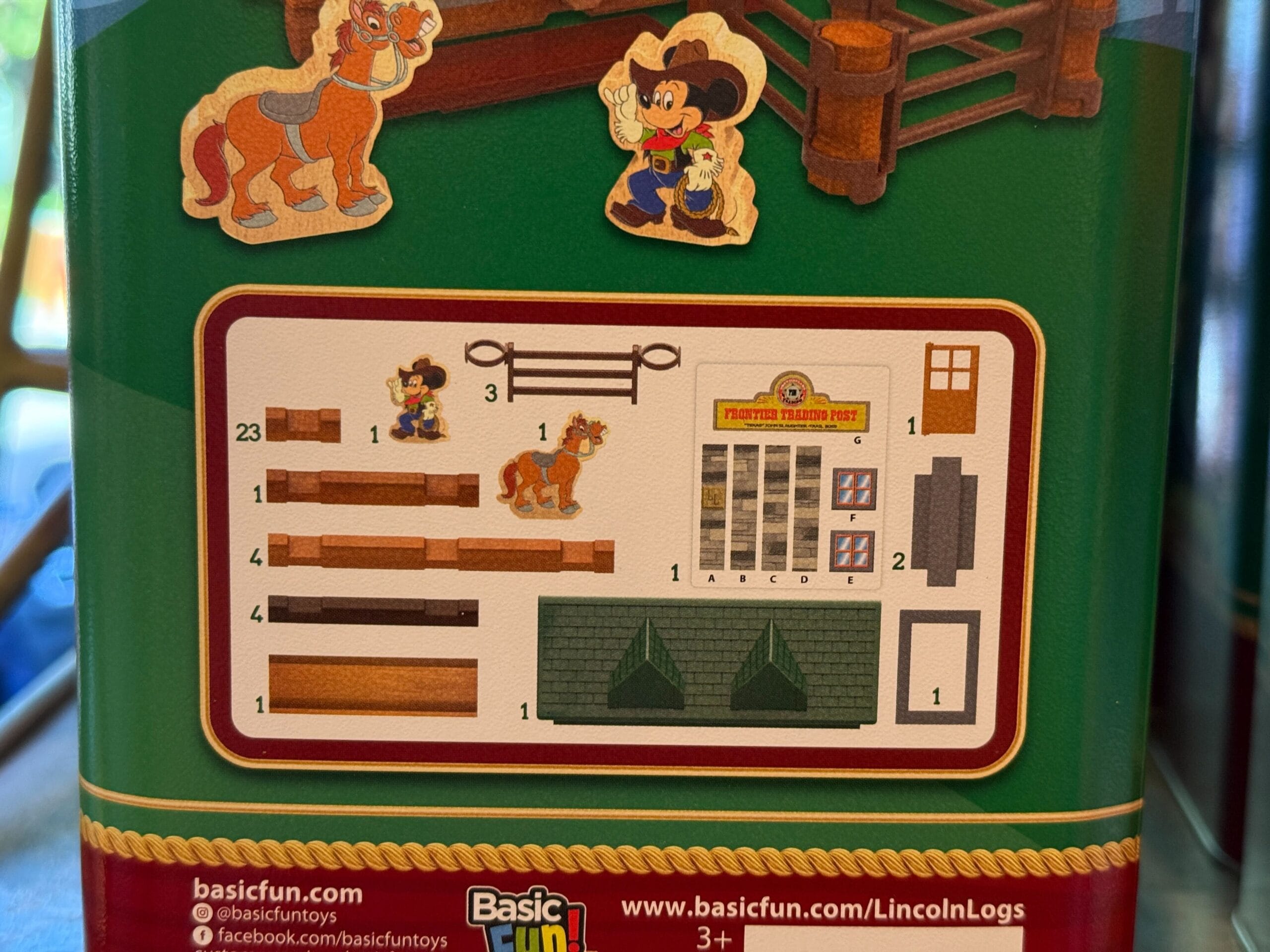 Instruction sheet with Mickey Mouse, a horse, and wooden log pieces for assembling a Lincoln Logs Frontier Trading Post set.
