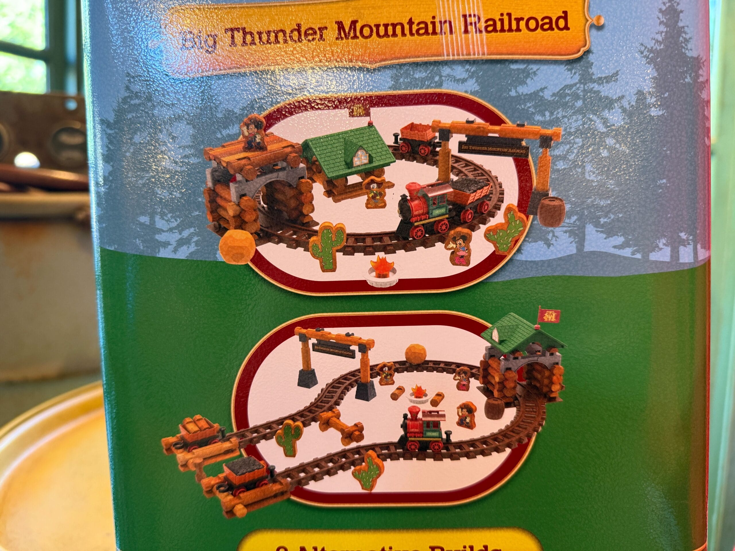 Toy train track set with trees and buildings, inspired by Frontierland’s Big Thunder Mountain Railroad.