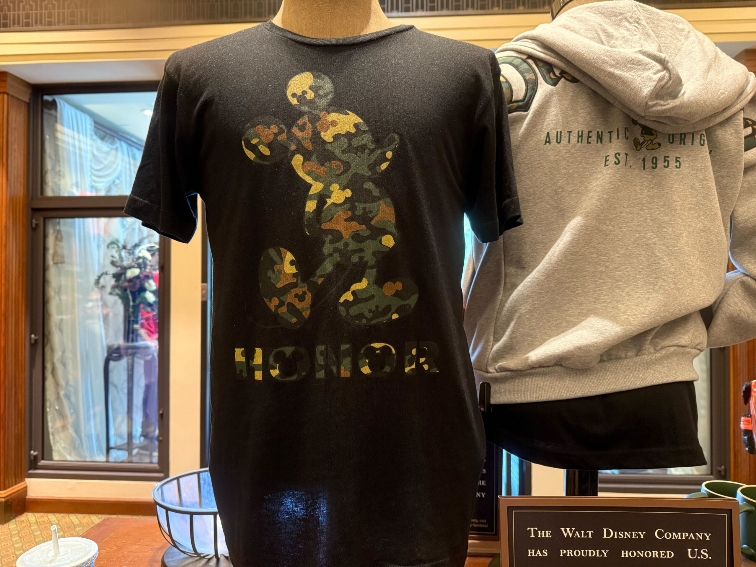 Black t-shirt with camouflage-pattern Mickey Mouse and "HONOR" on front with Mickey Mouse heads in the O.