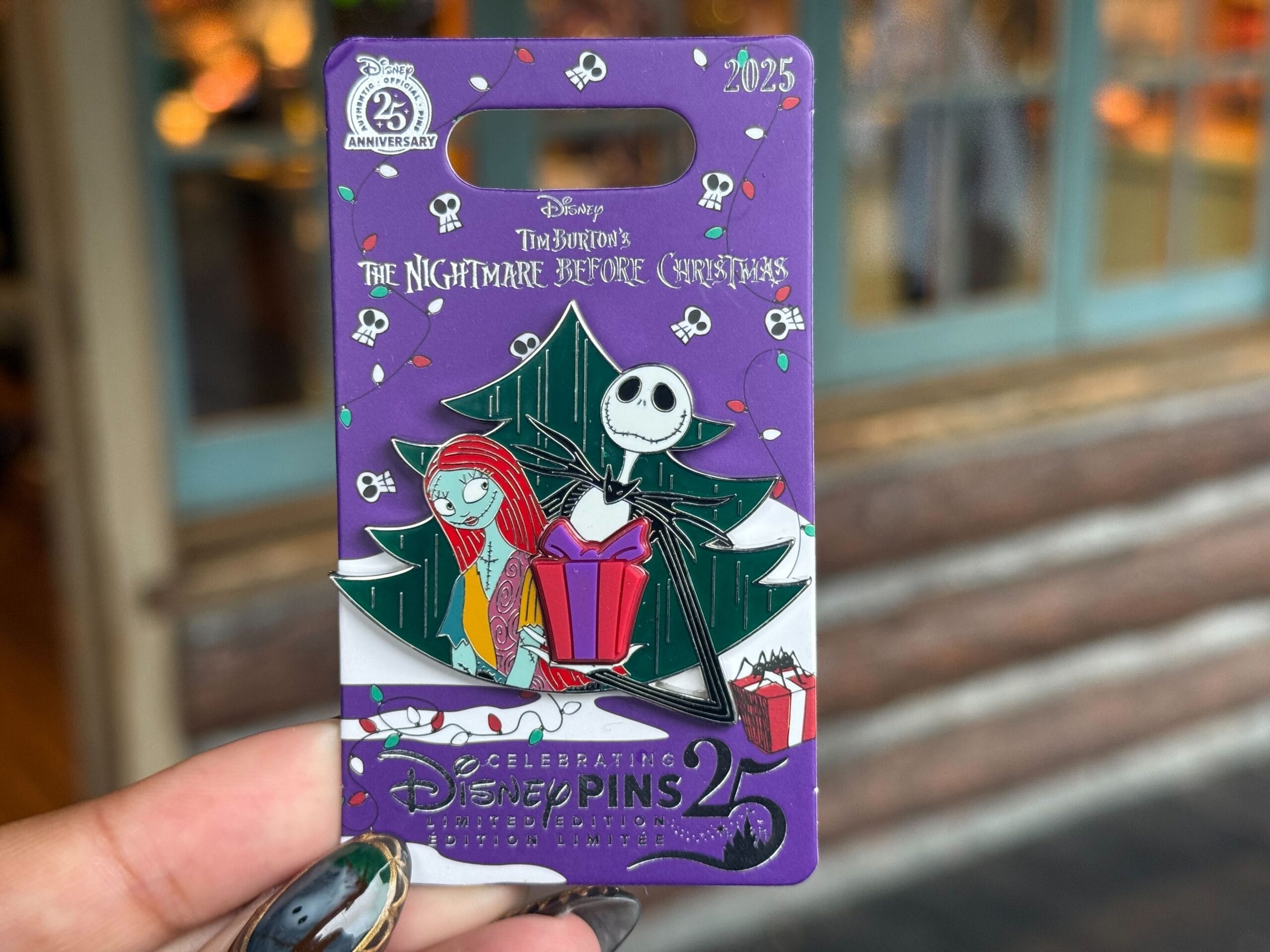 A Disneyland pin of Nightmare Before Christmas' Jack and Sally by a tree.