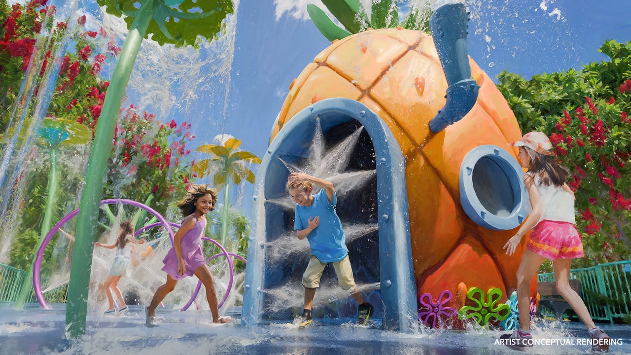 A boy and girl splash in a colorful water park; unlike Disney’s castle parks, Universal’s theming centers on movie-inspired play zones.